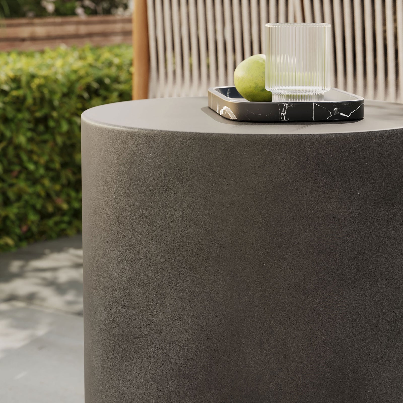 Top of gray concrete stool used as a tray-ready surface for drinks in a contemporary outdoor lounge || EEI-7088-GRY || detail_room