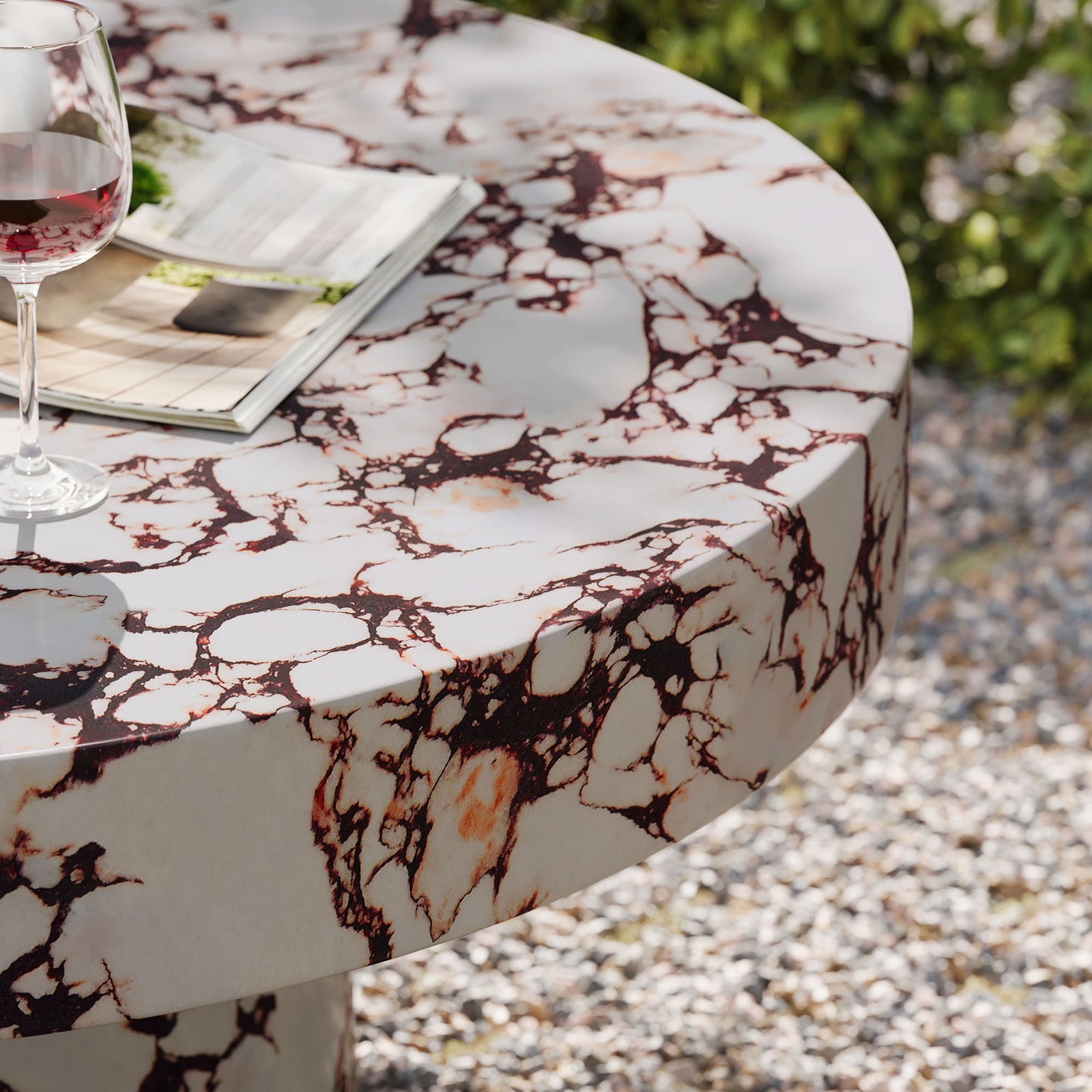 Red marble look coffee table used outdoors with wine glass and reading material on patio || EEI-7091-RED || detail_room