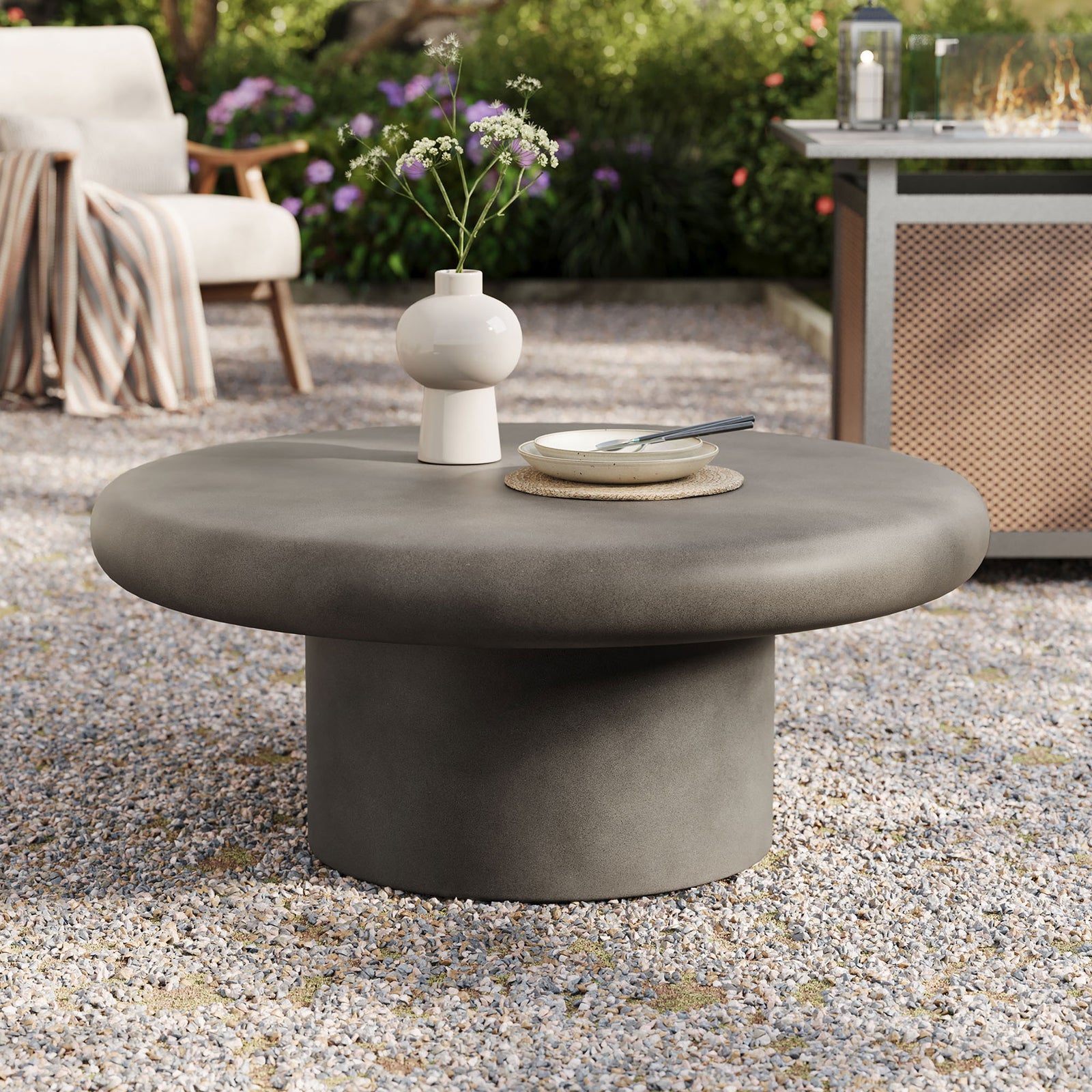 Low gray concrete round coffee table with cylindrical base creating a bold centerpiece for modern patio gatherings || EEI-7092-GRY || front_angle_room