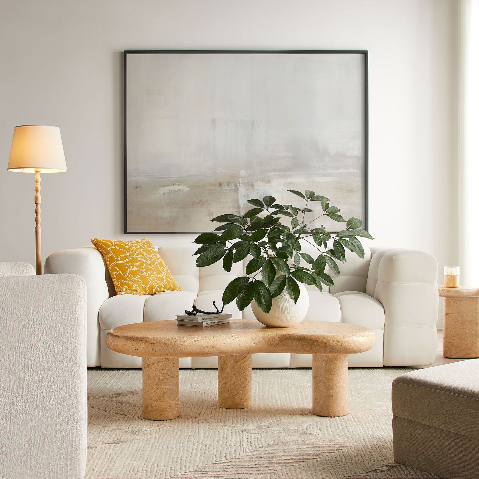 Faux travertine coffee table centers a bright living room, pairing organic curves with clean-lined seating || EEI-7093-TRV || front_room