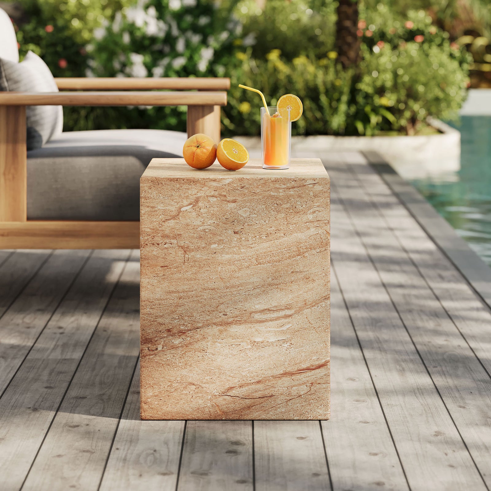 Travertine-effect concrete side table by a poolside lounge, ideal for drinks, books, or decor. || EEI-7096-TRV || front_angle_room