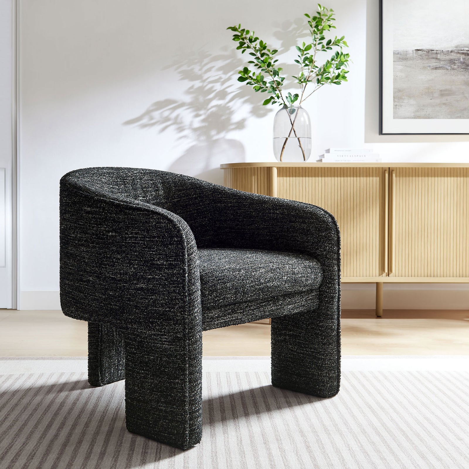 Statement barrel chair elevates spaces with its charcoal boucle and bold three-legged form || EEI-7101-CHA || front_angle_room