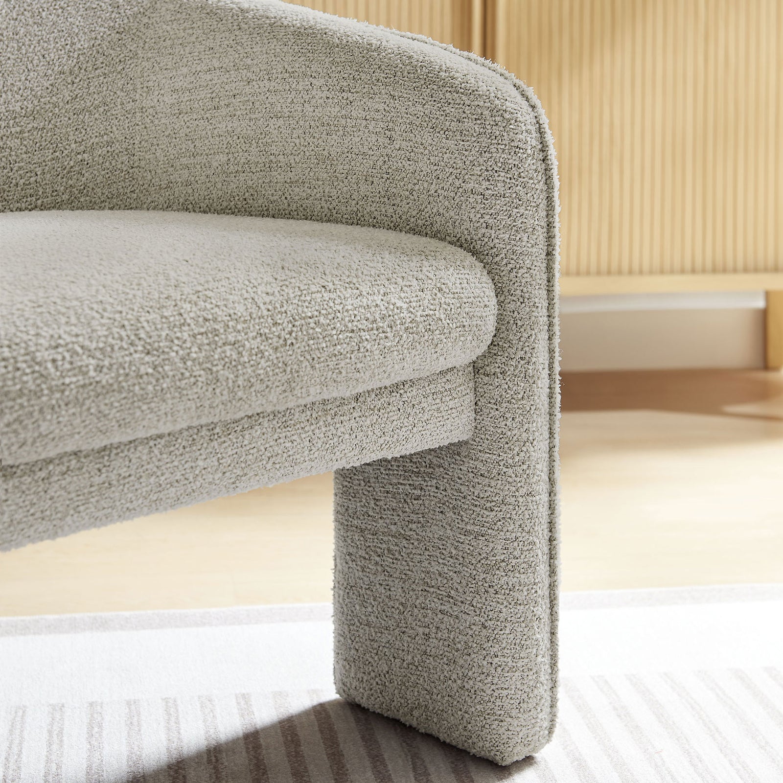 Textured boucle and tailored edges add inviting comfort to the sculpted arm and seat || EEI-7101-PCH || detail_room