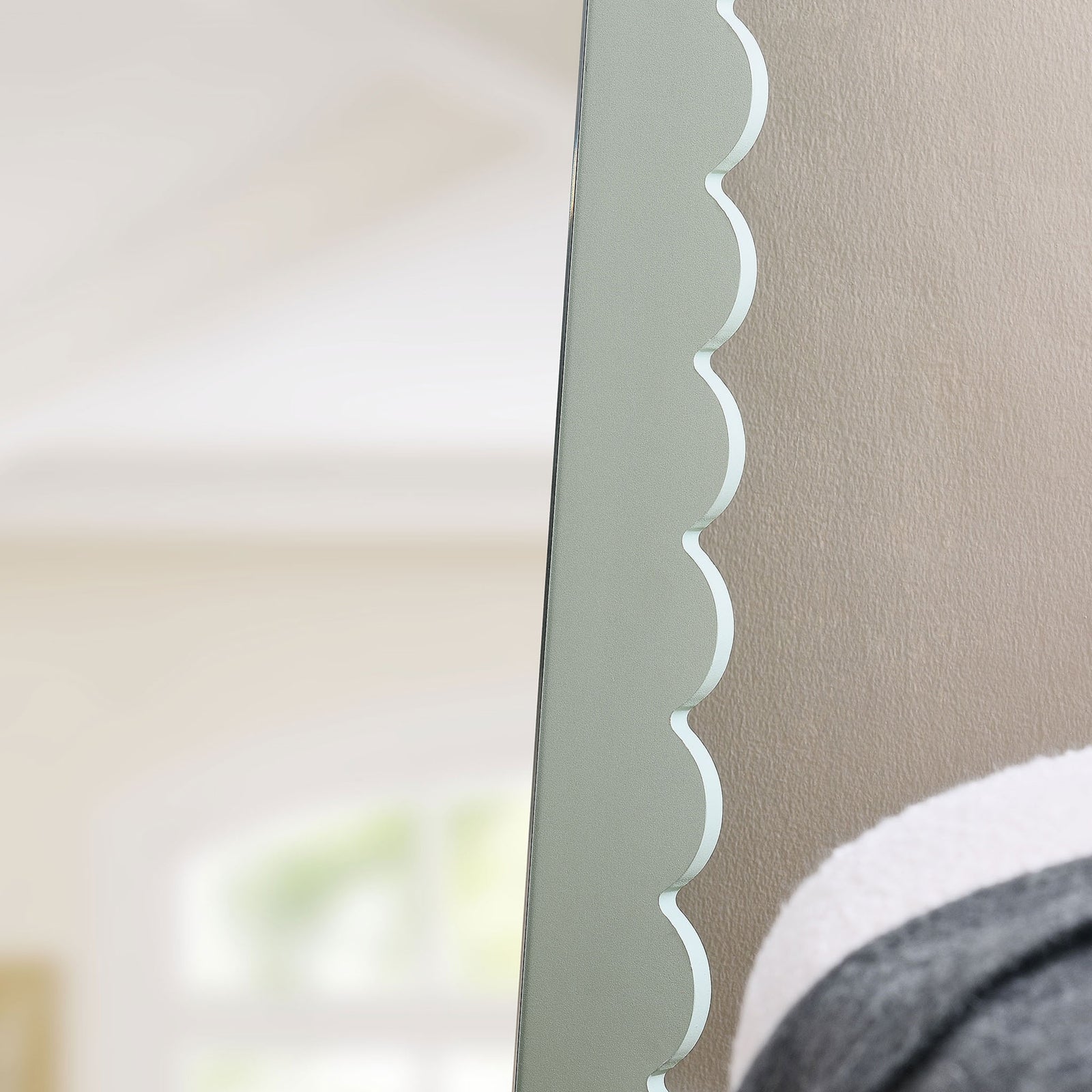 Scalloped sage mirror frame adding playful texture against a softly lit bedroom wall || EEI-7117-SGE || detail_room