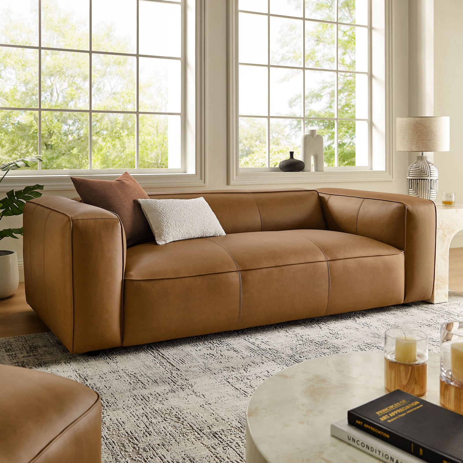 Modern camel vegan leather sofa styled with accent pillows in a bright, airy living room || EEI-7119-CAM || front_angle_room
