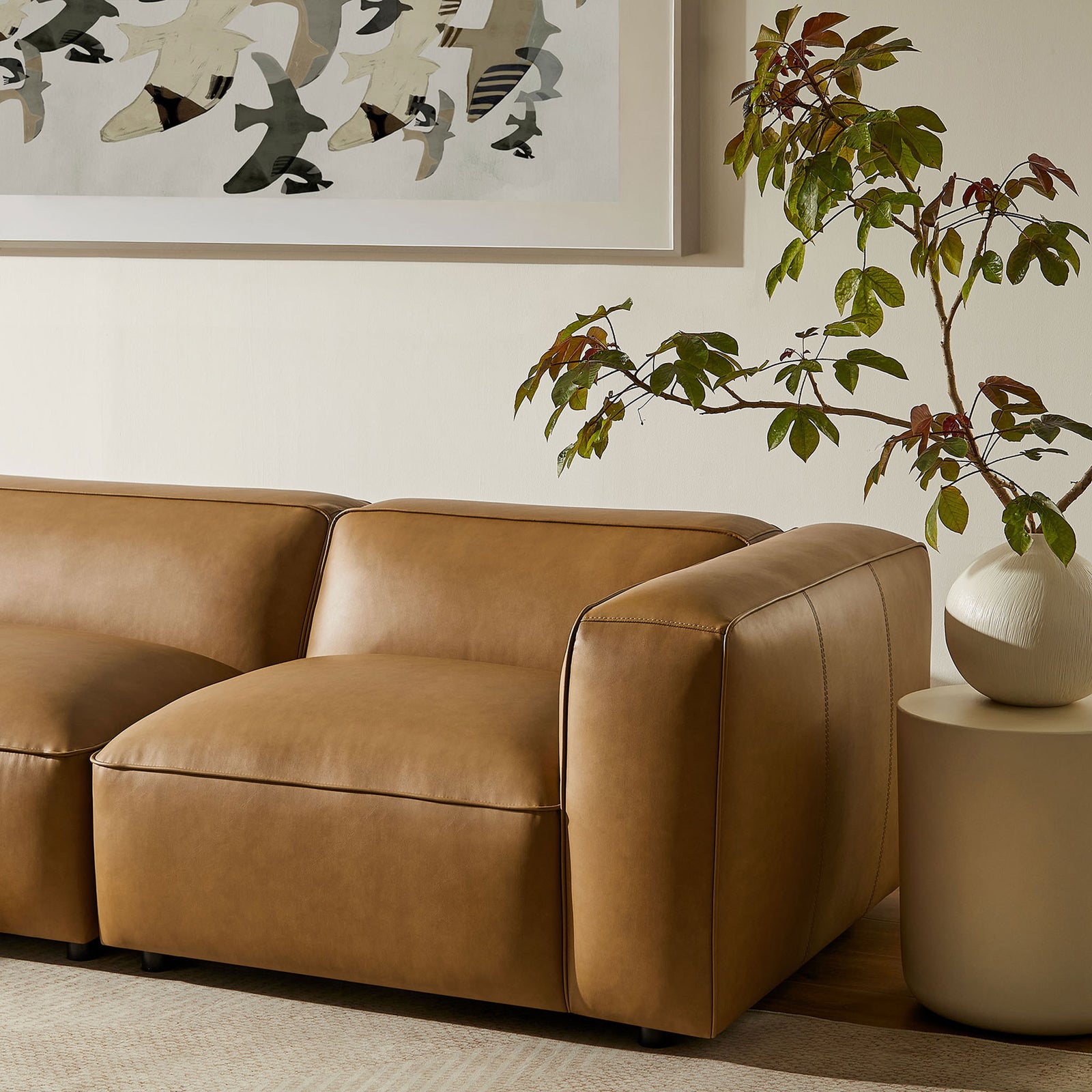Camel modular sofa corner with plush seat, curved arm, and modern decor accents in a cozy living room || EEI-7128-CAM || detail_room