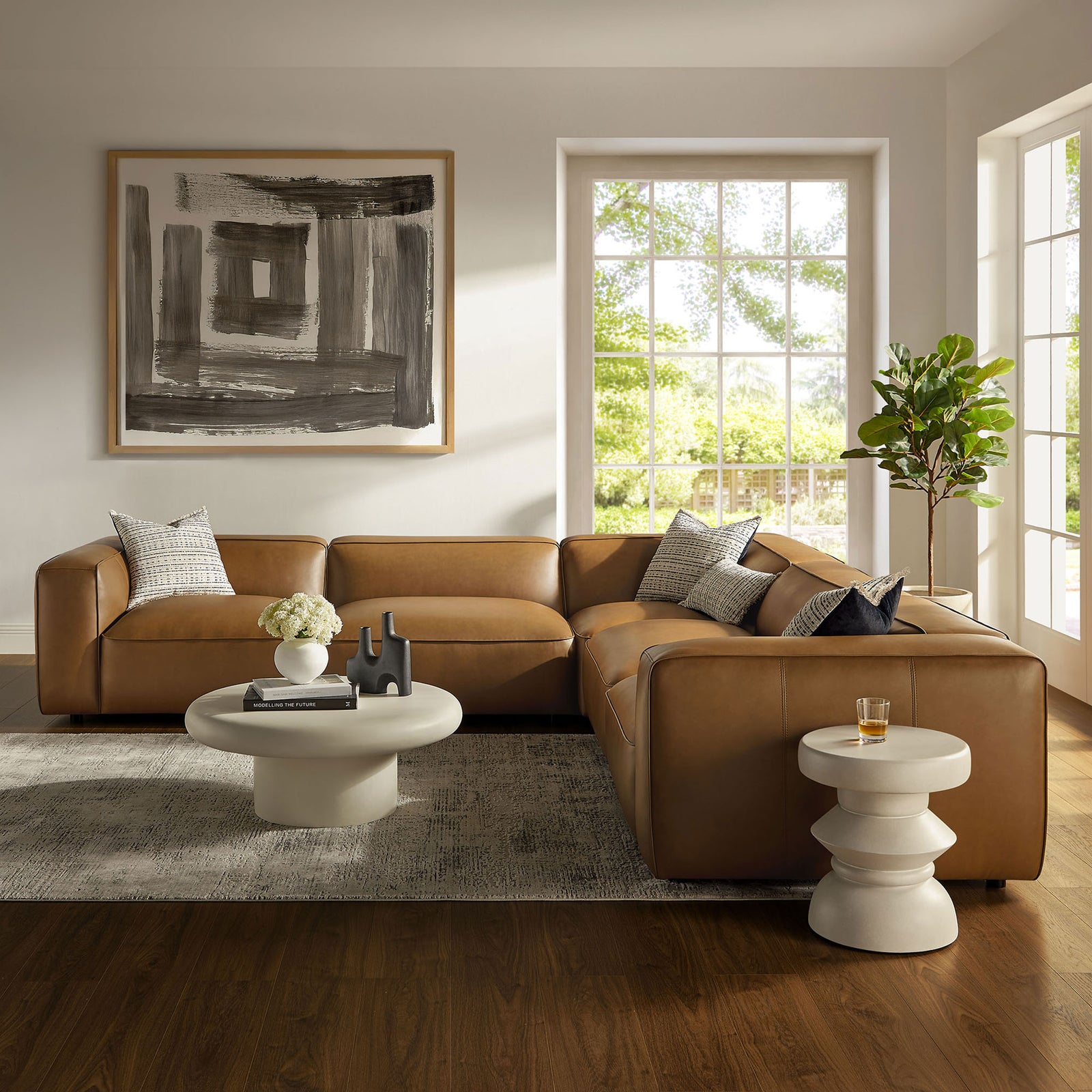 Camel modular sectional styled in a bright living room with sculptural tables and modern decor || EEI-7129-CAM || front_angle_room