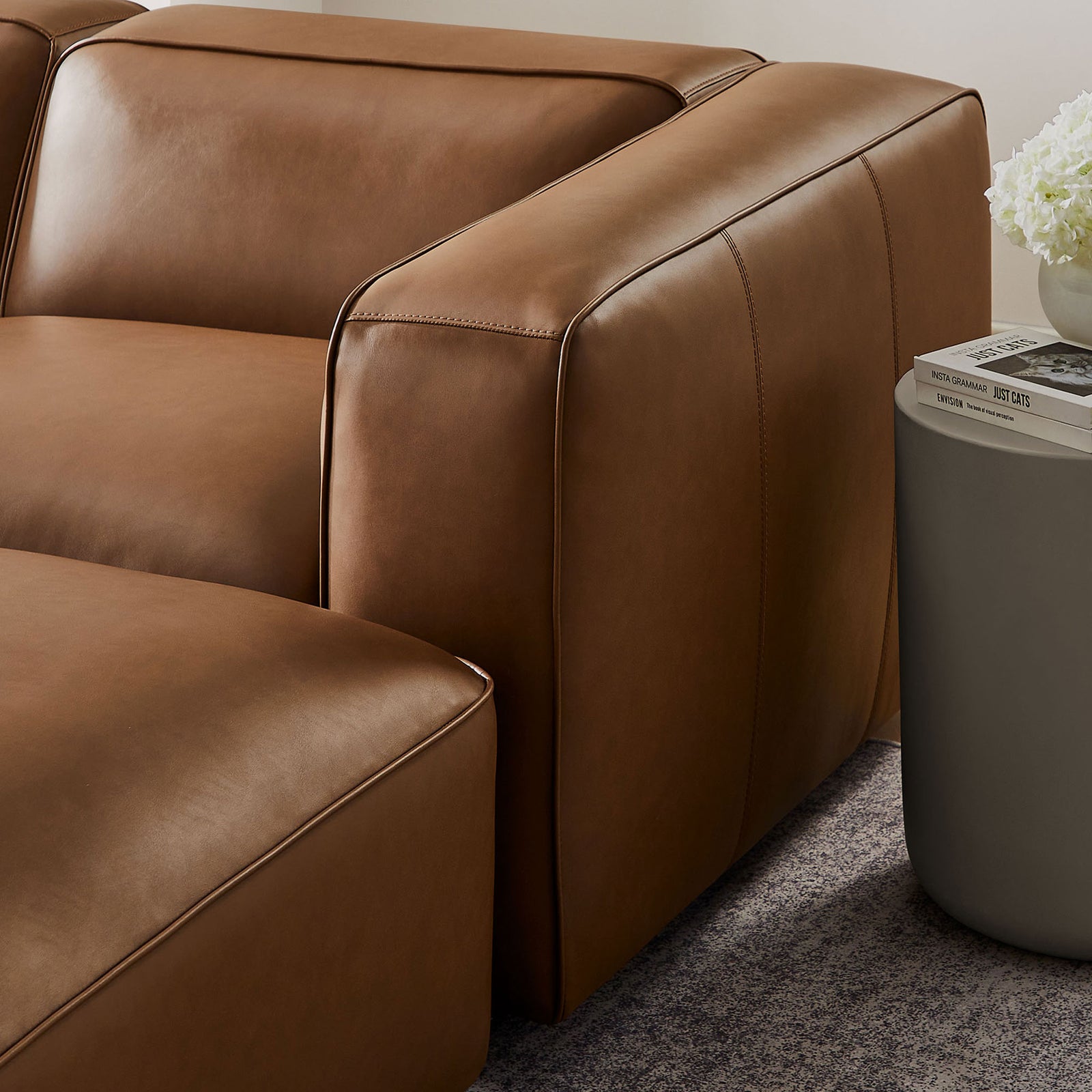 Wide coffee vegan leather armrest with tailored stitching beside a modern side table || EEI-7131-COF || detail_room