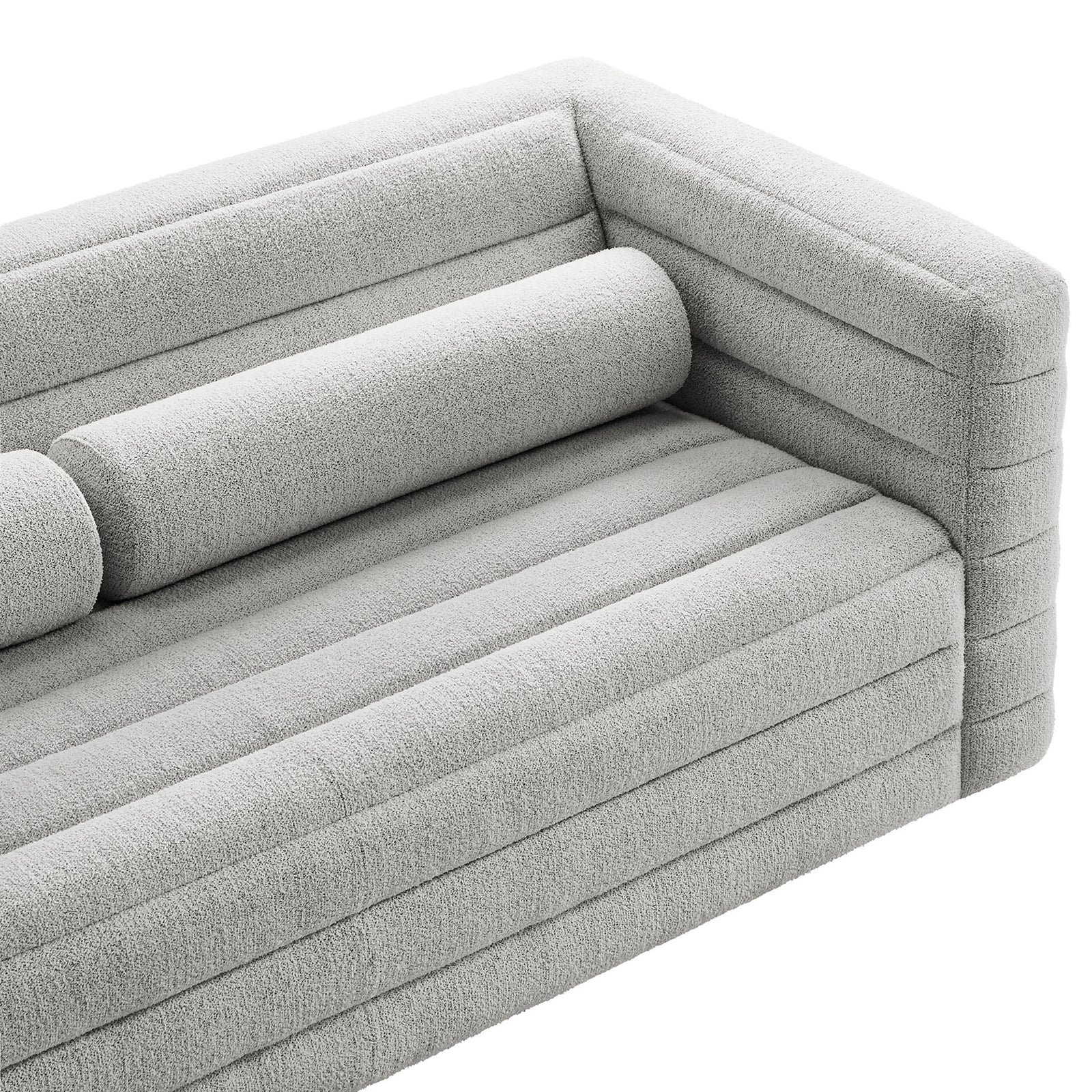 Detail of the channel-tufted seat and arm with matching bolster pillow in soft textured boucle upholstery || EEI-7136-NPT || detail_studio