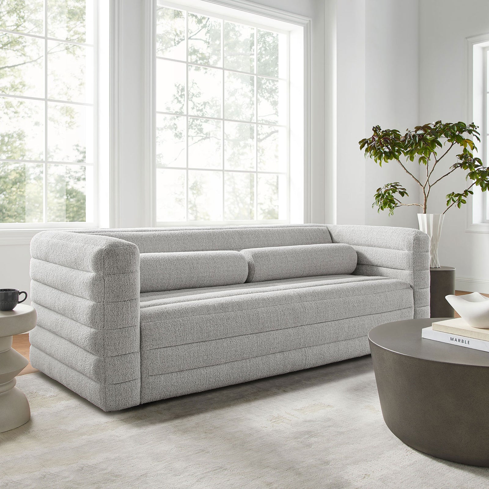 Relle channel-tufted boucle sofa styled in a bright modern living room with soft rug and sculptural tables || EEI-7136-NPT || front_angle_room