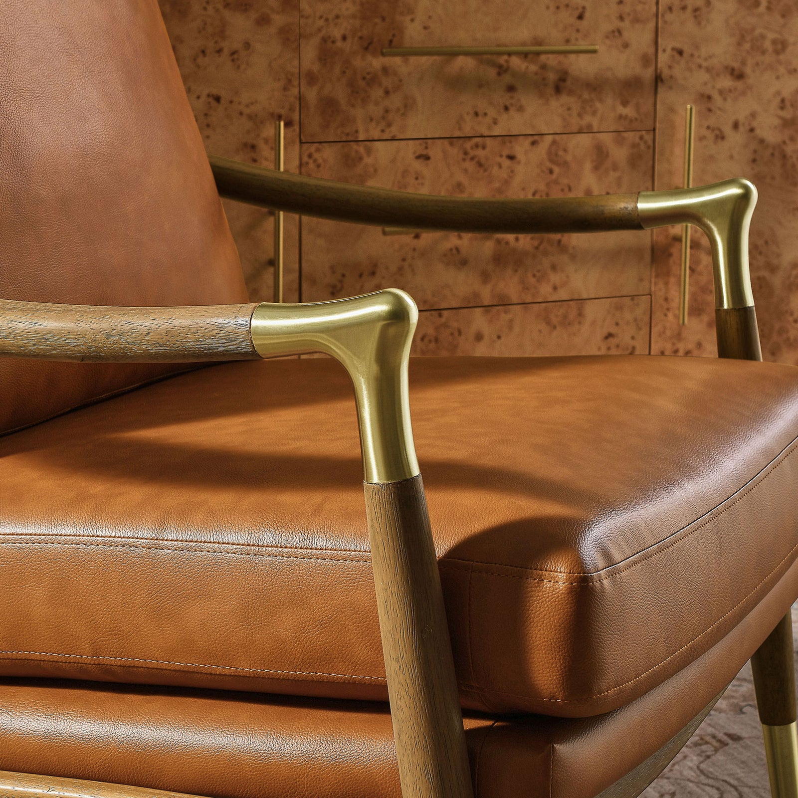Polished brass accents highlight the gently arched arm and neatly stitched seat cushion || EEI-7138-TAN-WAL || detail_room