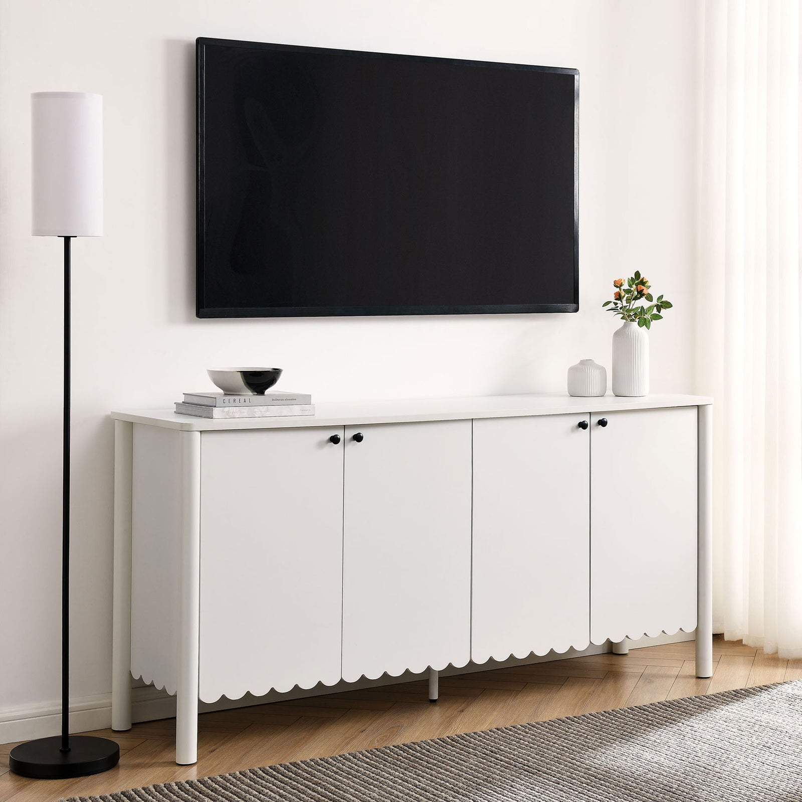 White scalloped sideboard used as a media console beneath a wall-mounted TV with minimalist decor || EEI-7153-WHI || front_room