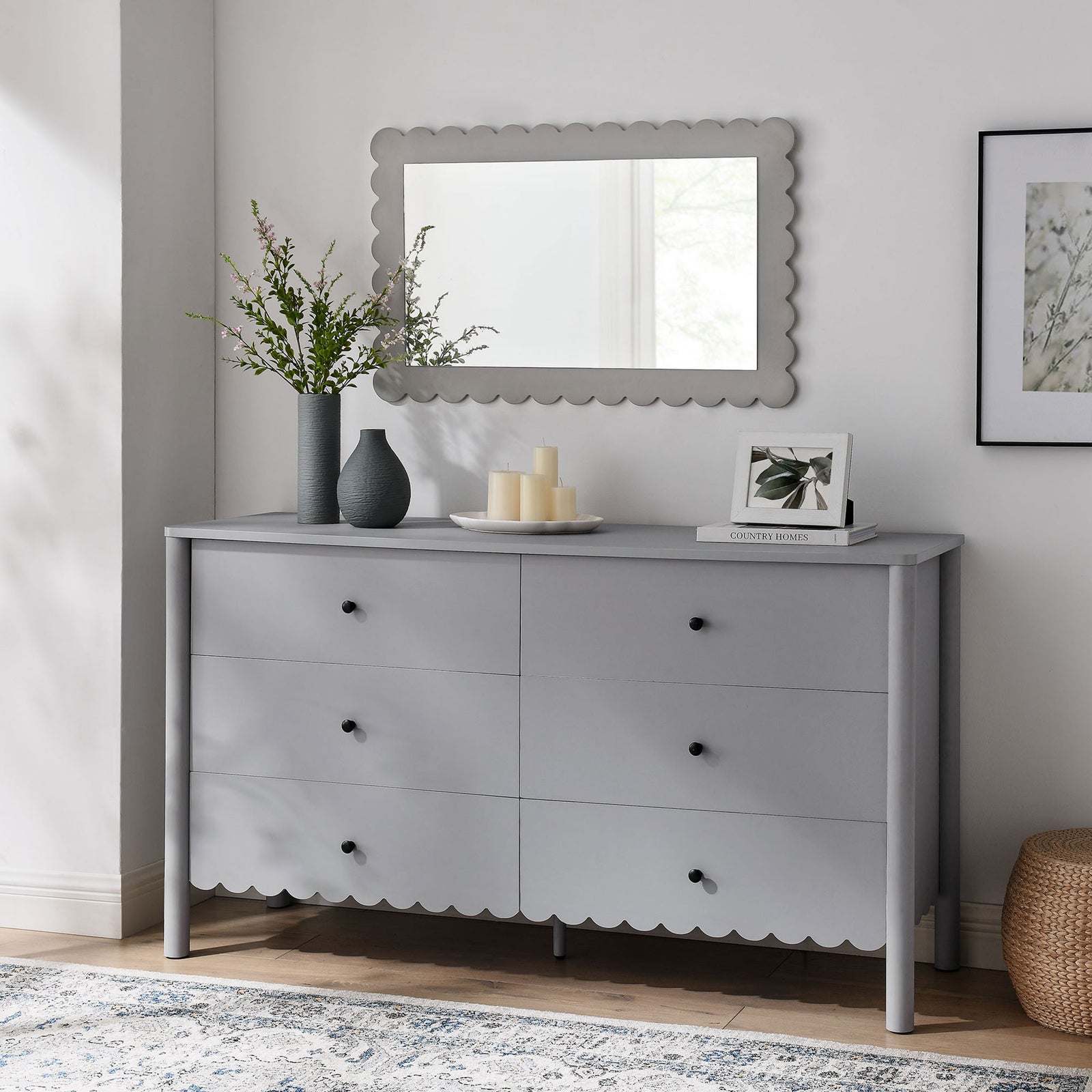 Emmeline dresser in light gray anchored by scalloped mirror and decor in a bright airy room. || EEI-7157-LGR || front_angle_room