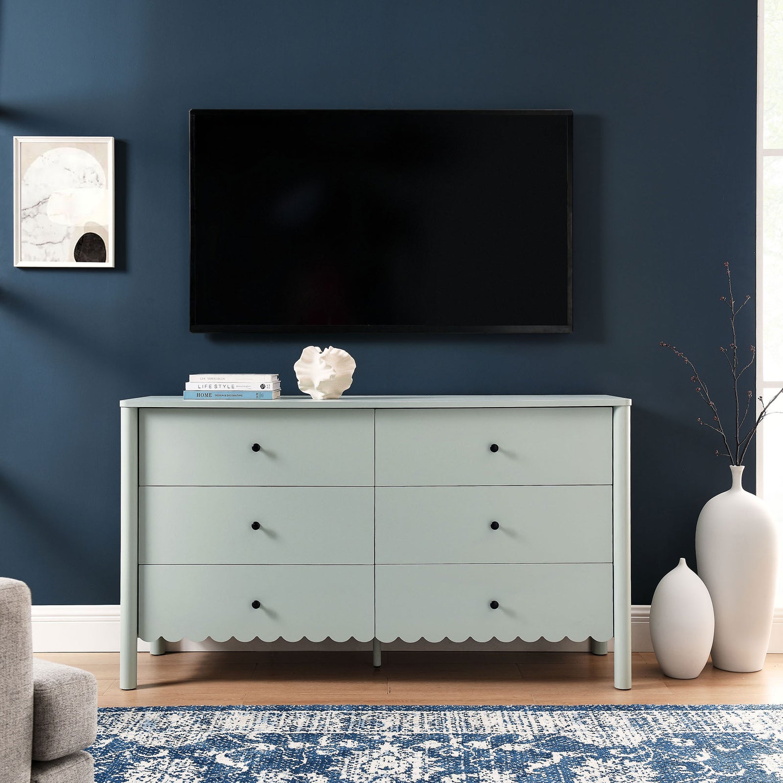 Sage green dresser placed beneath a wall-mounted TV, anchoring a modern living room setup. || EEI-7157-SGE || front_room