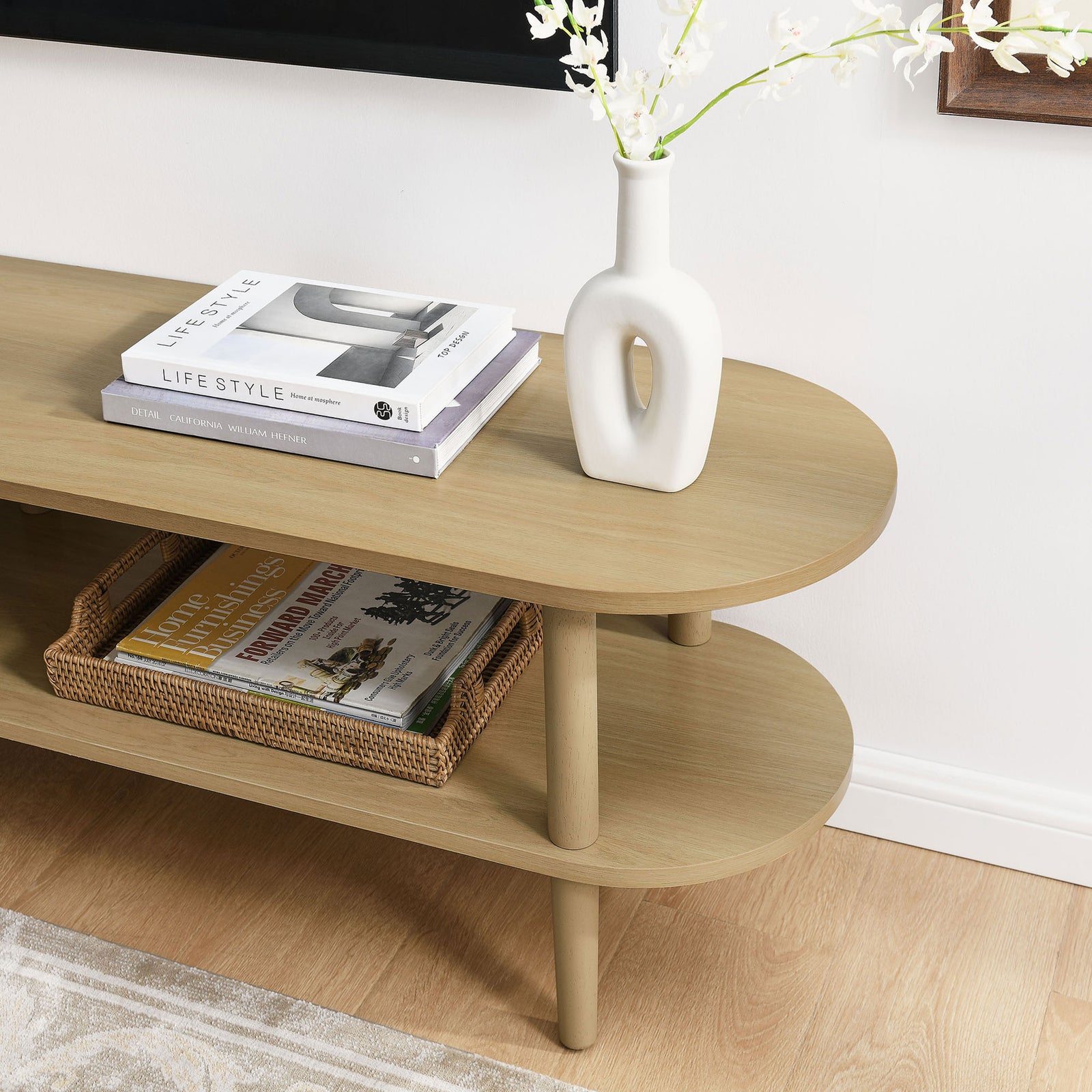 Light oak Torus TV stand styled with books, a vase, and basket to show everyday storage || EEI-7158-OAK || detail_room