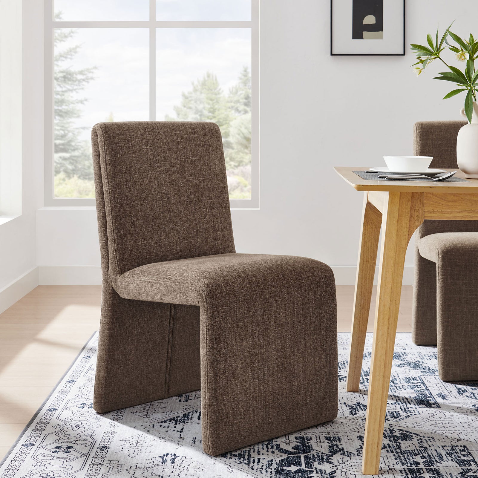 Mocha Emory dining chair styled by a wood table on a patterned rug for a warm modern look. || EEI-7185-MOC || front_angle_room