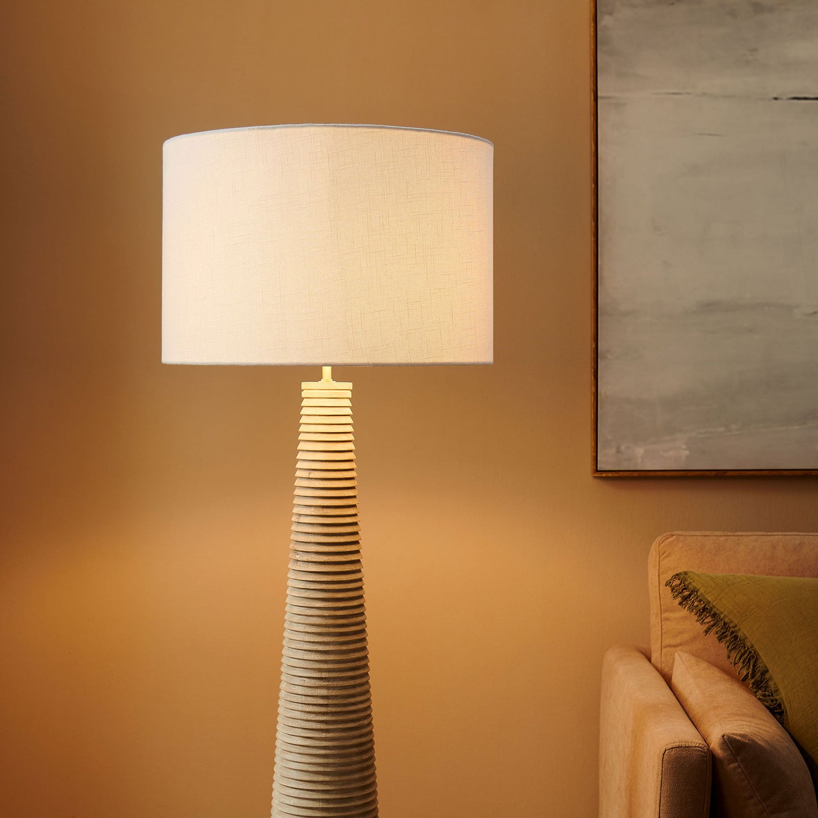 Warmly glowing drum shade topping the ribbed wood base in a cozy living space || EEI-7190-WHI-GRY || shade_on_room