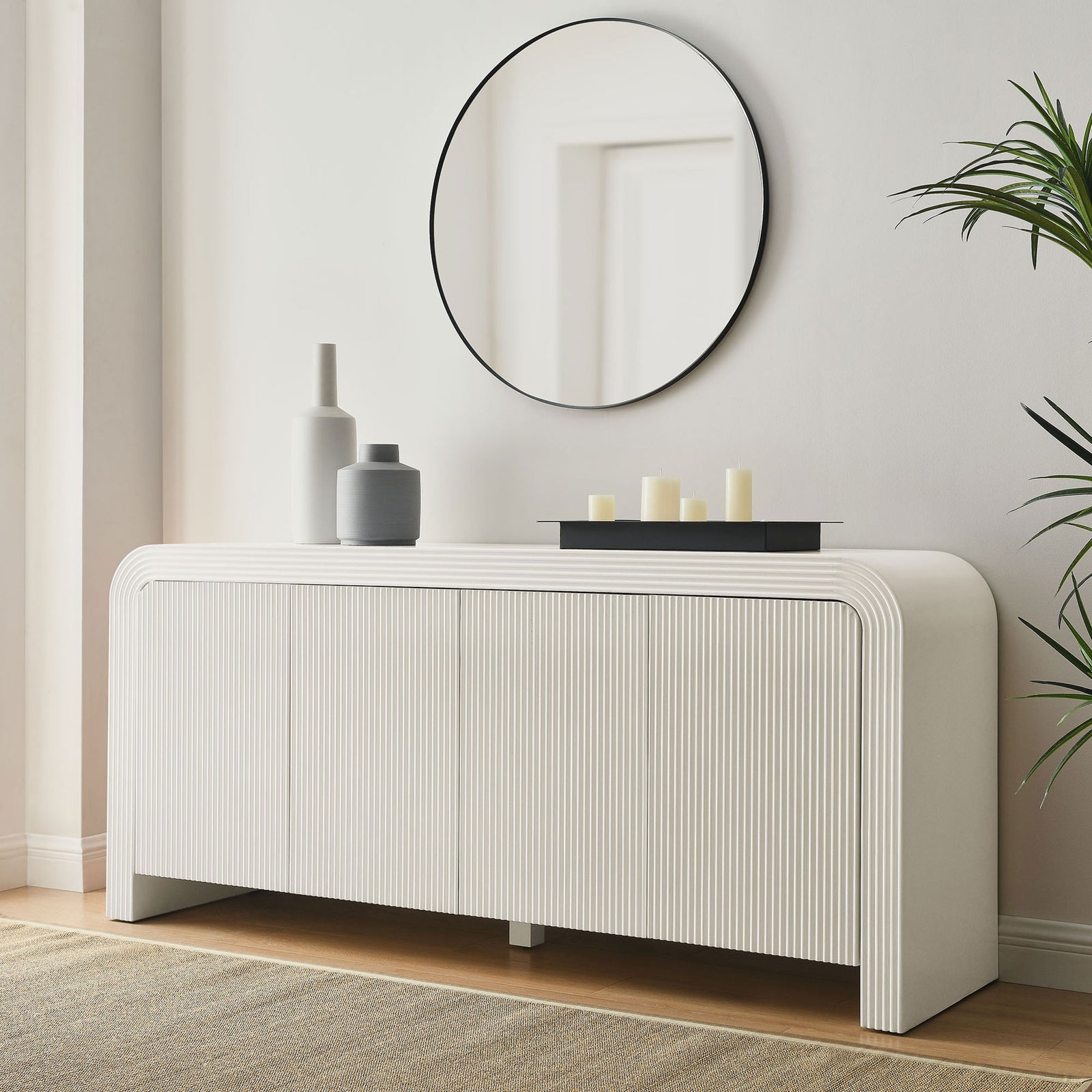 White fluted sideboard styled as an entryway console with round mirror, candles, and ceramic vases || EEI-7198-IVO || front_room