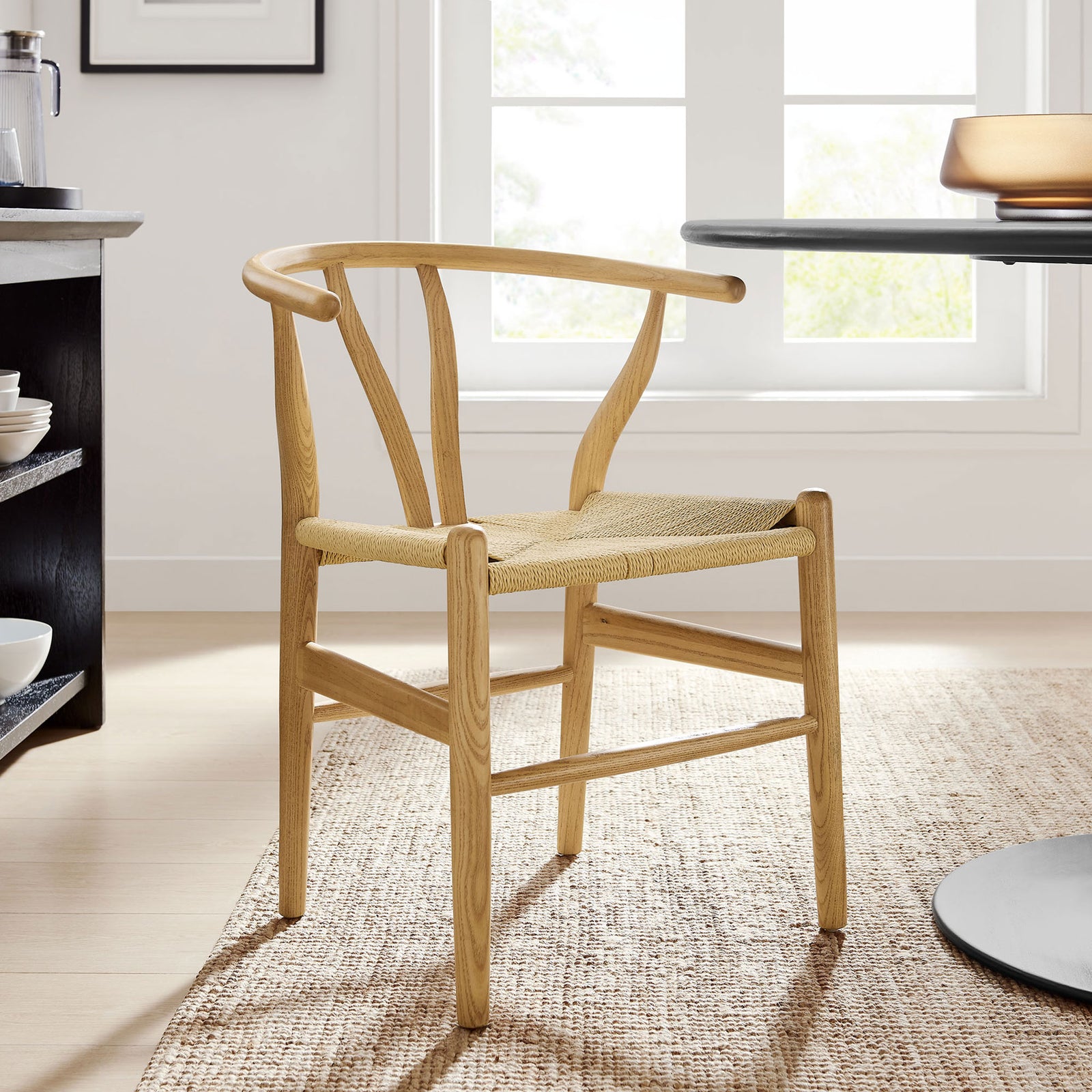 Natural wood dining chair with rope seat adding warmth to a bright modern dining space || EEI-7200-NAT || front_angle_room