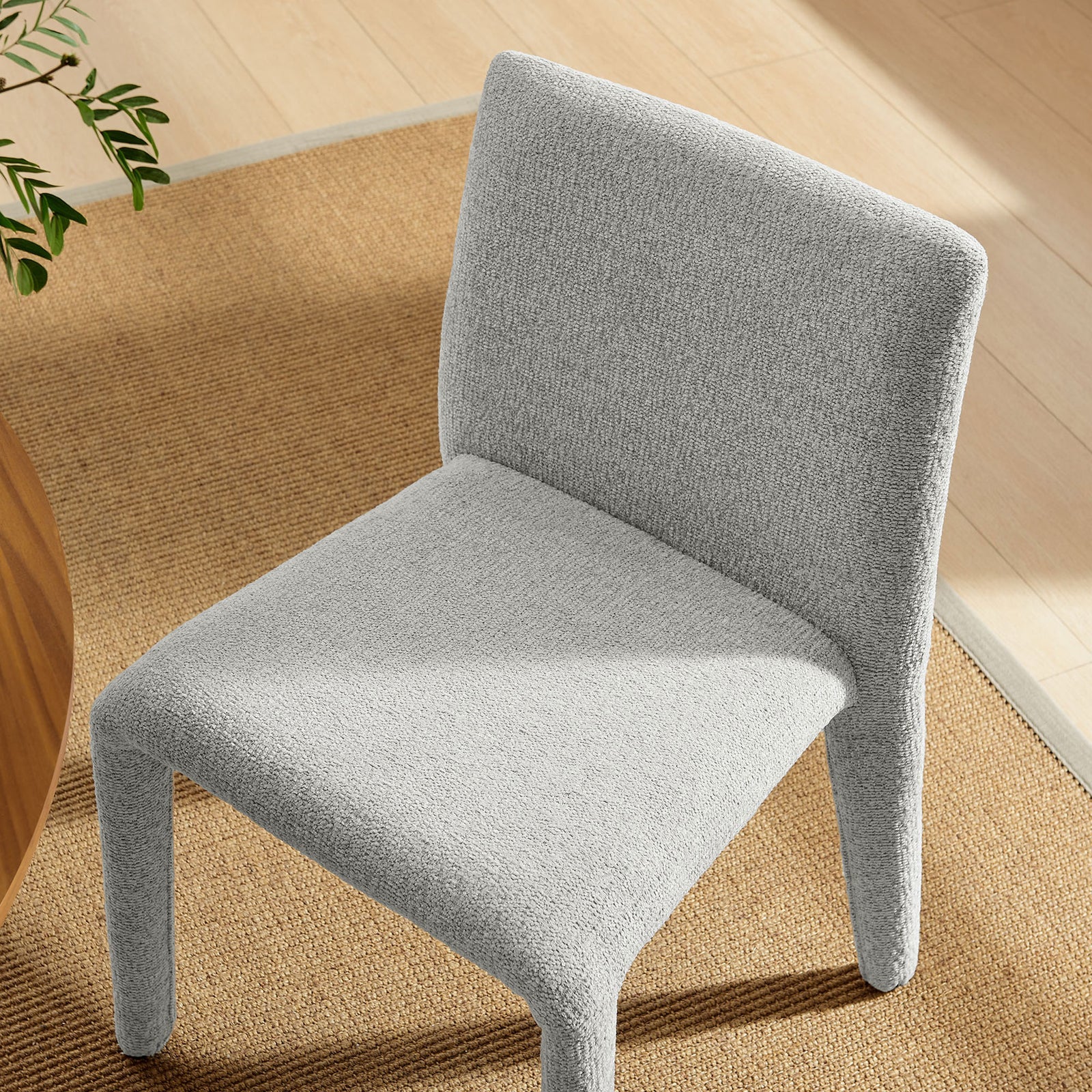 Rhodes dove gray upholstered dining chair styled beside a warm wood table on a natural woven rug. || EEI-7222-DOV || top_angle_room