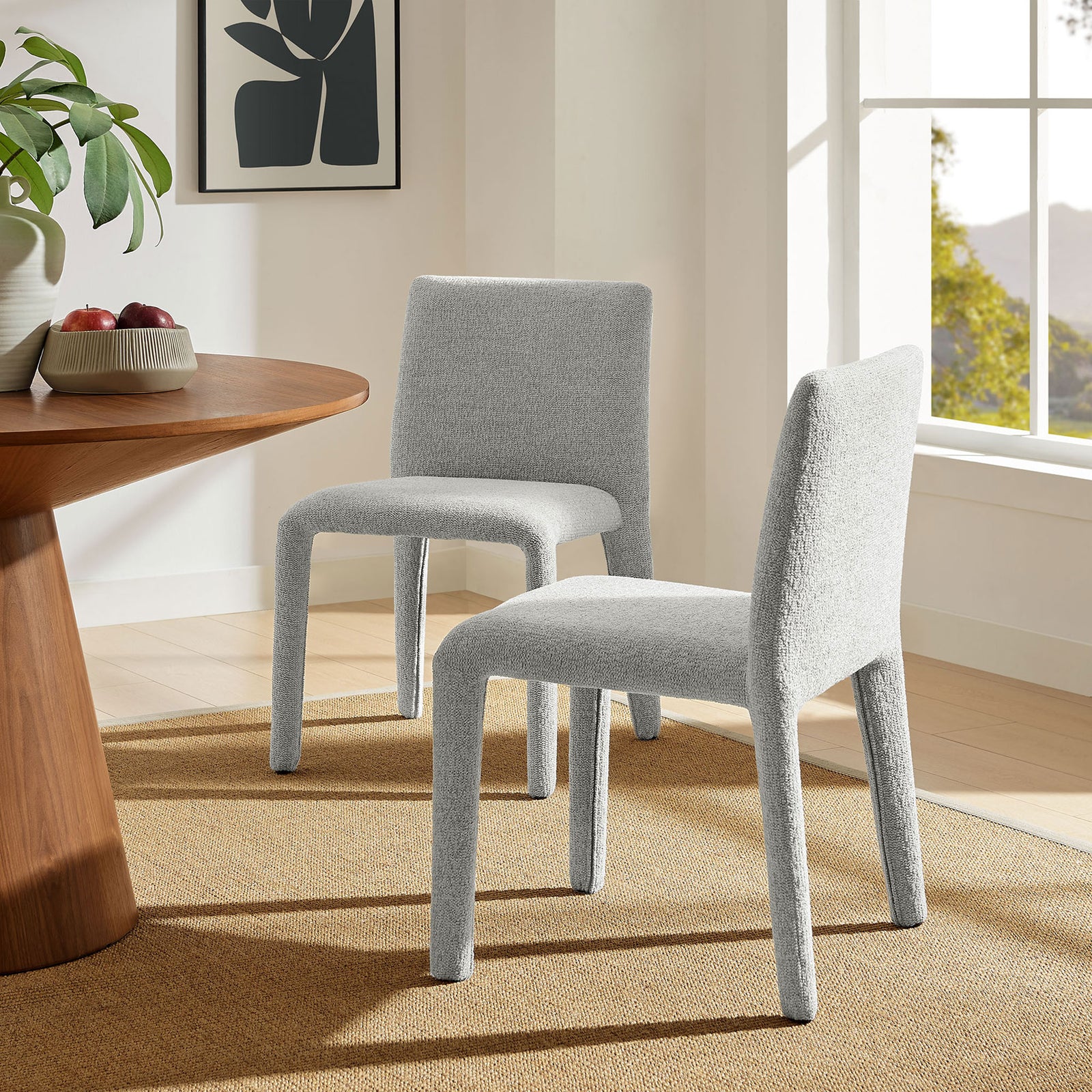 Two Rhodes dove gray dining chairs arranged in a bright, airy dining room with light wood accents. || EEI-7222-DOV || front_angle_room