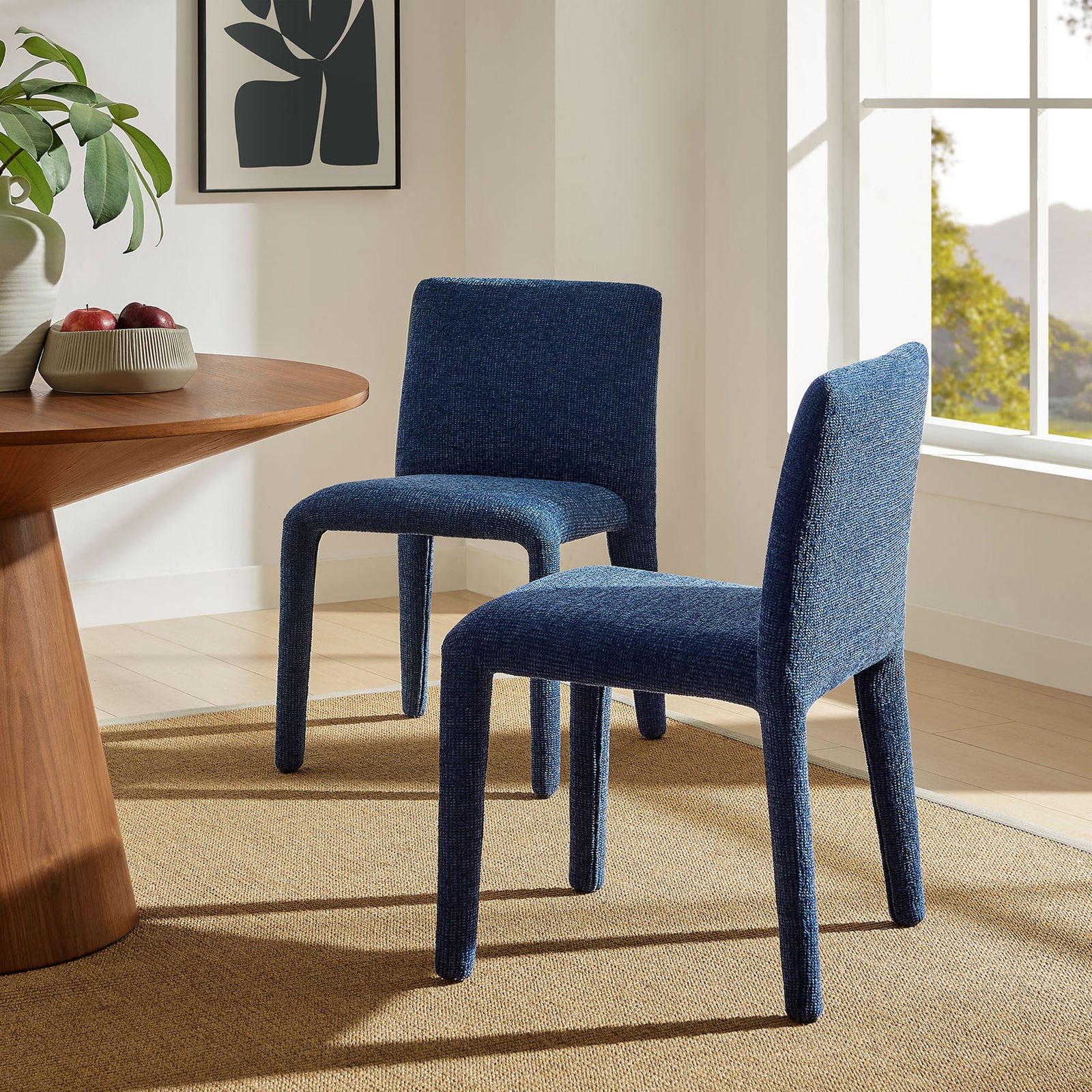 Pair of Rhodes navy chenille dining chairs styled around a wood table on a warm woven rug. || EEI-7222-NAV || front_angle_room