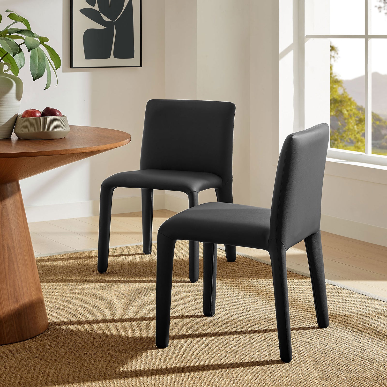 Pair of black vegan leather dining chairs creating a modern look in a bright, airy dining room || EEI-7223-BLK || front_angle_room