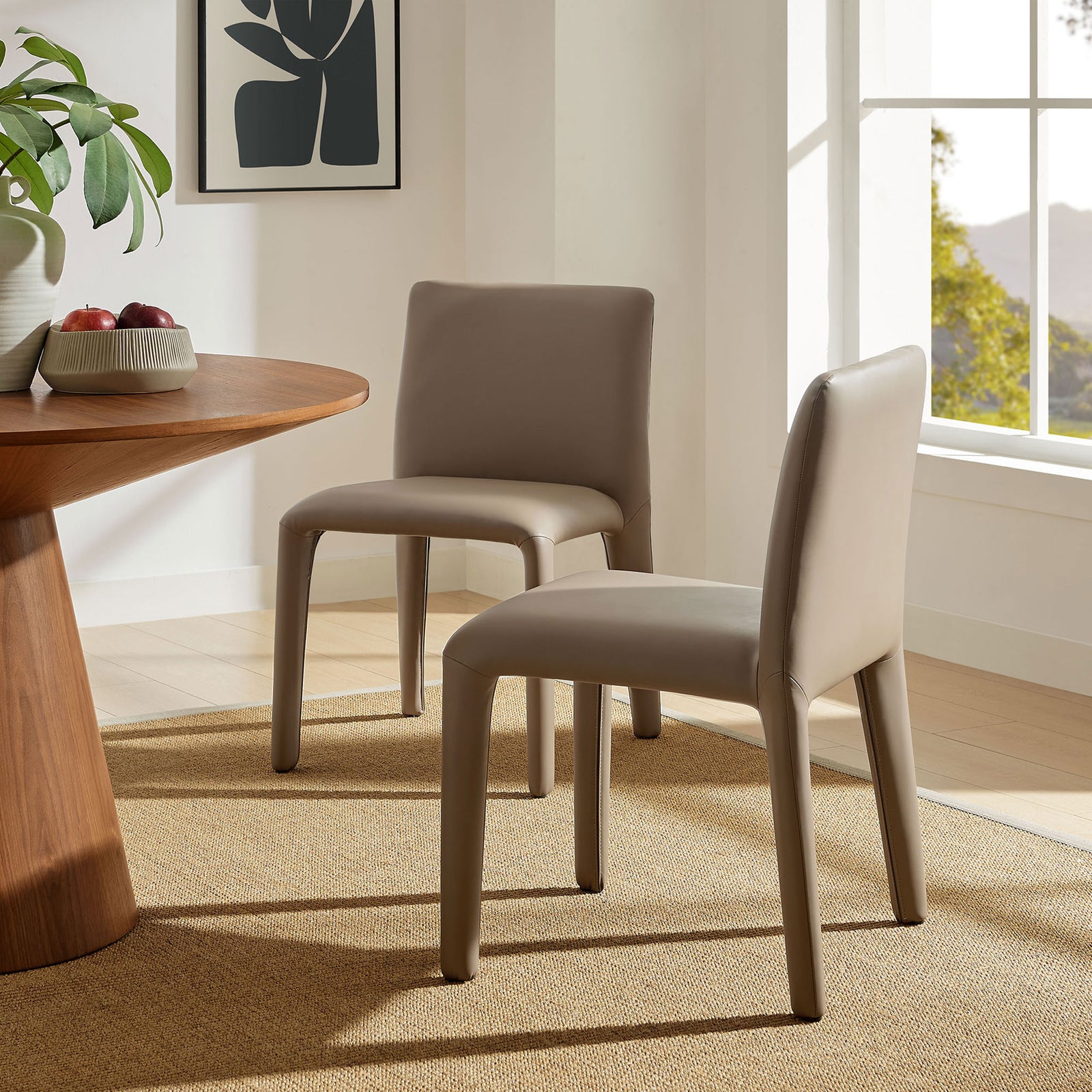 Pair of Rhodes mushroom brown dining chairs around a contemporary table in a bright, airy dining space || EEI-7223-MUS || front_angle_room