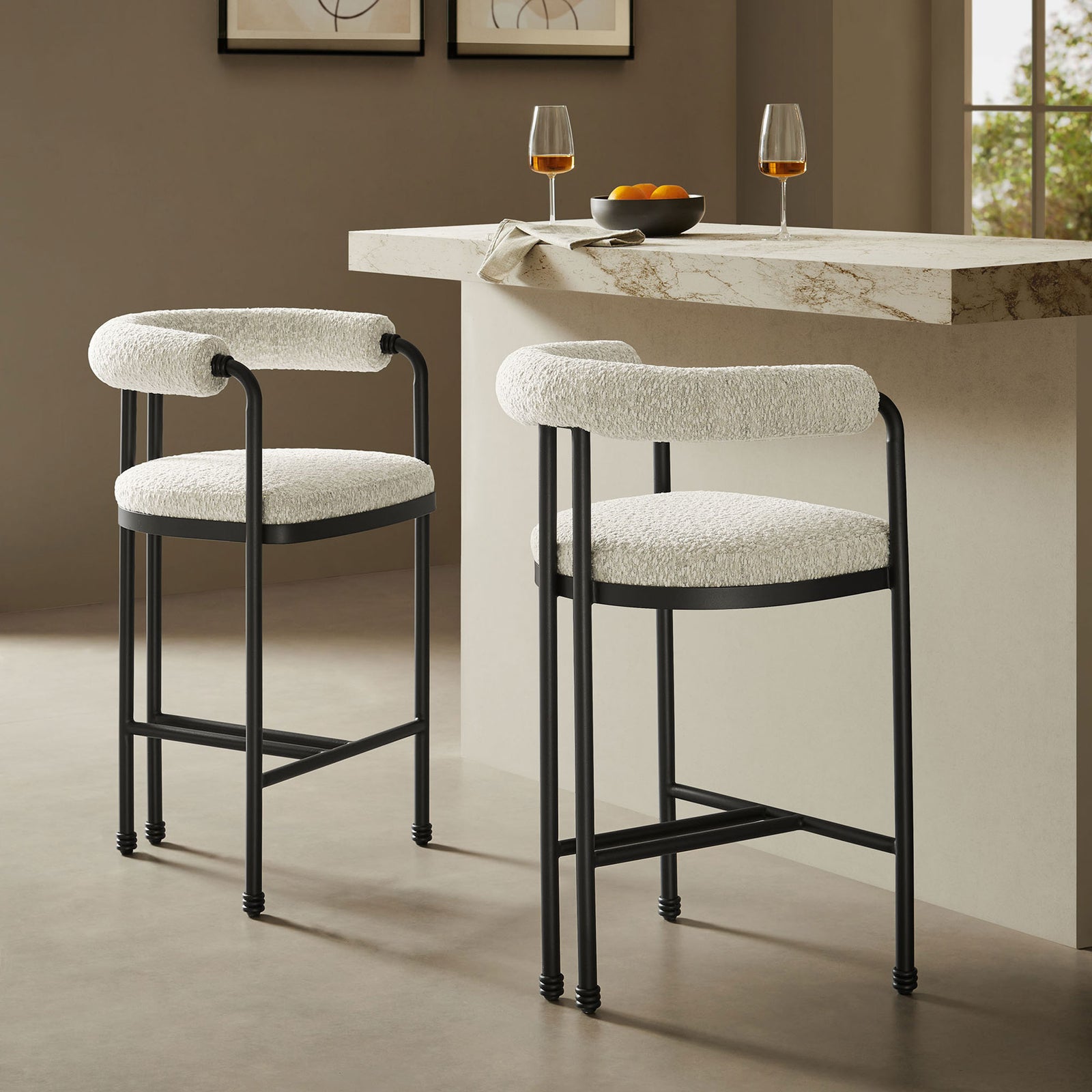 Stylish pair of boucle counter stools elevates a modern kitchen island with soft curves and black frames || EEI-7226-BLK-PRL || front_angle_room
