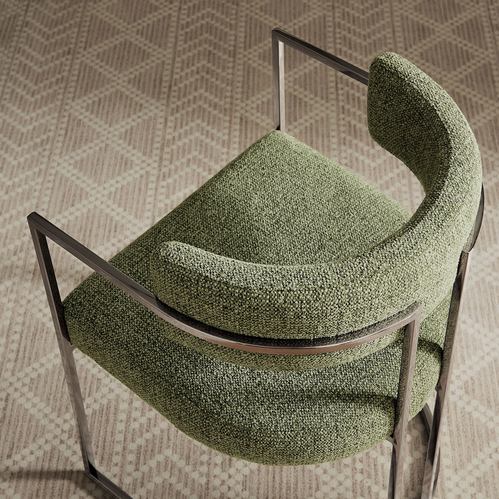 Huron chair placed on a patterned rug, emphasizing its curved seat and wraparound backrest || EEI-7228-SLV-LEA || top_angle_room