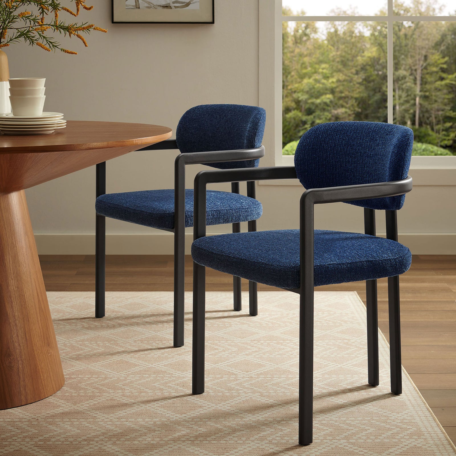 Two navy barrel dining chairs paired with a modern wood table in a bright, inviting dining room. || EEI-7229-BLK-NAV || front_angle_room