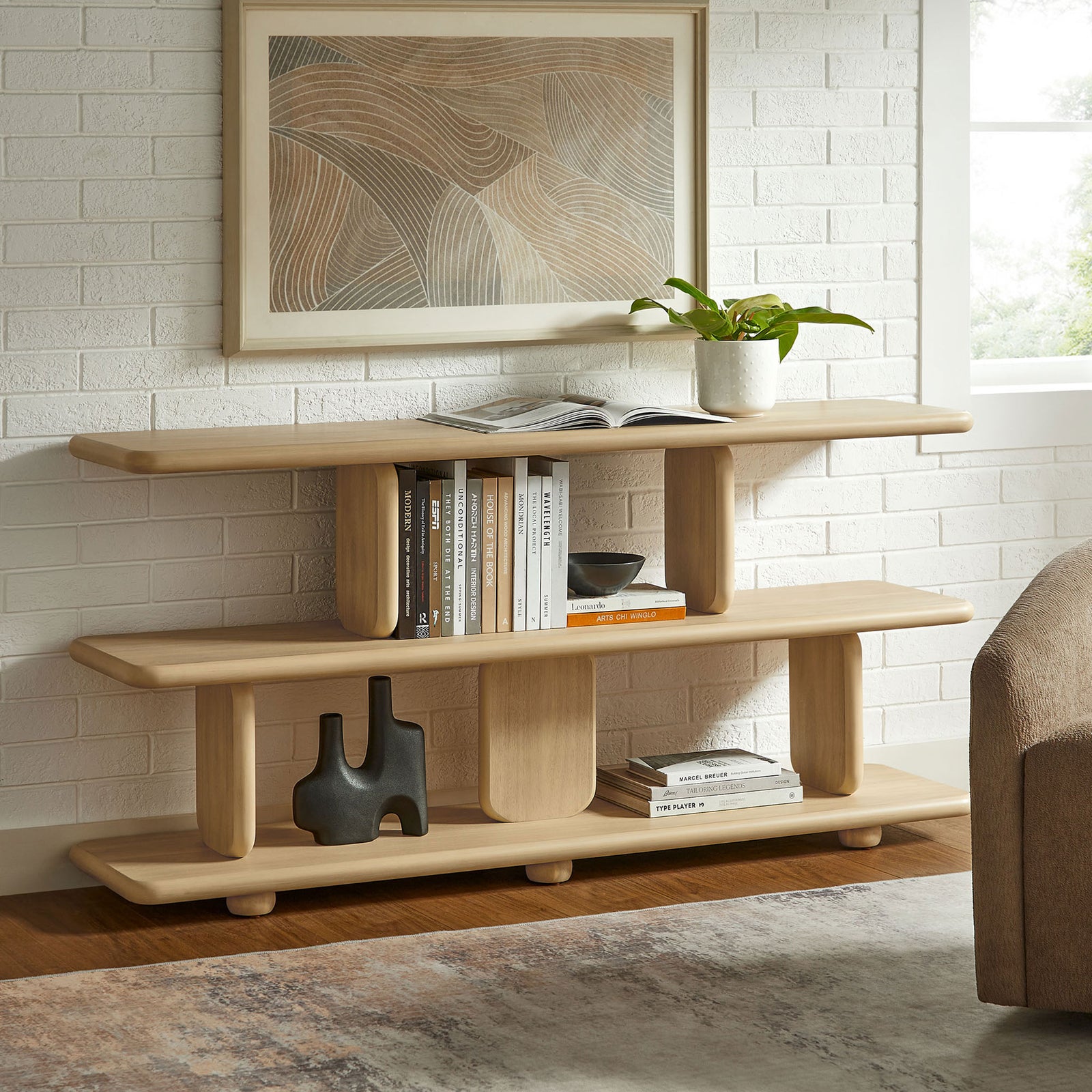 Sculptural natural bookshelf styled with books and decor for a warm, modern look || EEI-7232-NAT || front_room