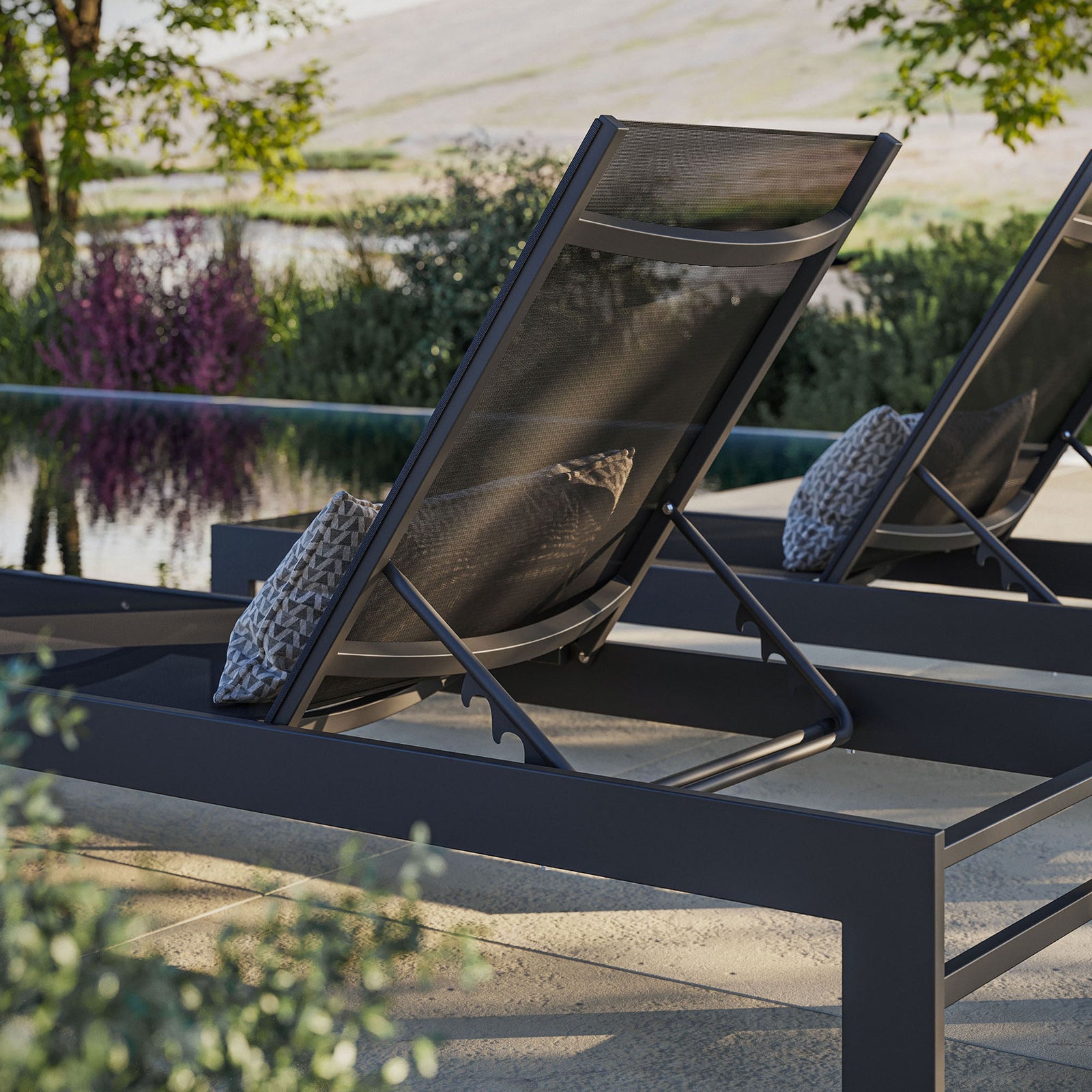 Gray mesh chaise beside a pool, emphasizing the curved backrest and supportive sling seat || EEI-7235-GRY || detail_room