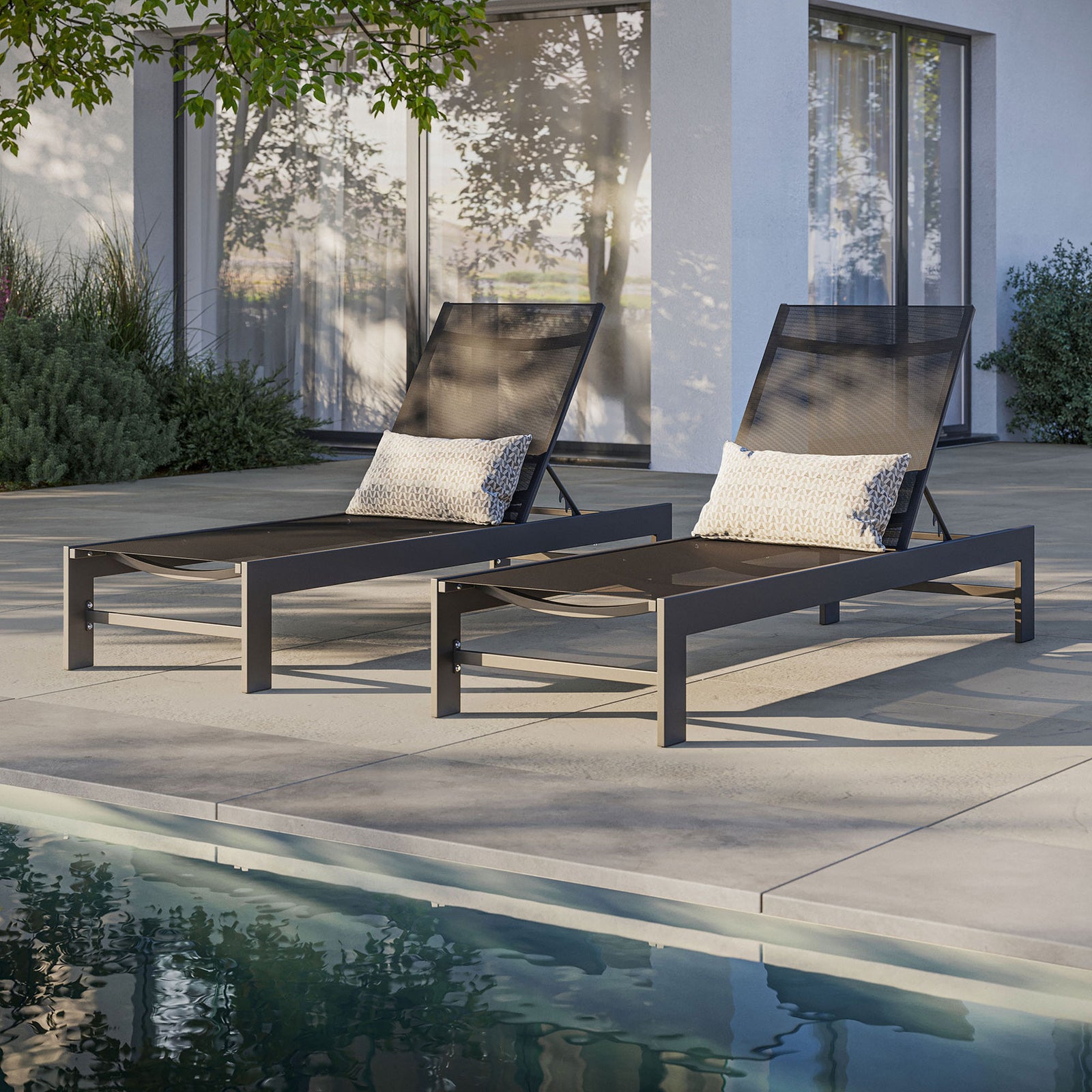 Pair of gray mesh chaises arranged by the pool with accent pillows for relaxed outdoor seating || EEI-7235-GRY || front_angle_room