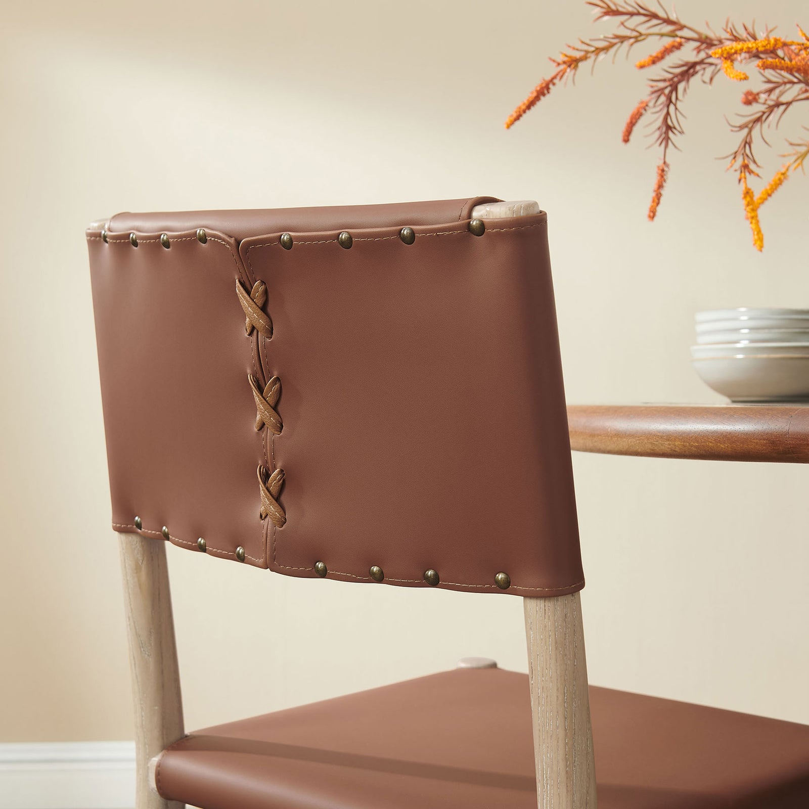 Vegan leather backrest with laced seam and brass-tone studs adds rustic charm alongside your dining table || EEI-7240-NAT-SDL || detail_room