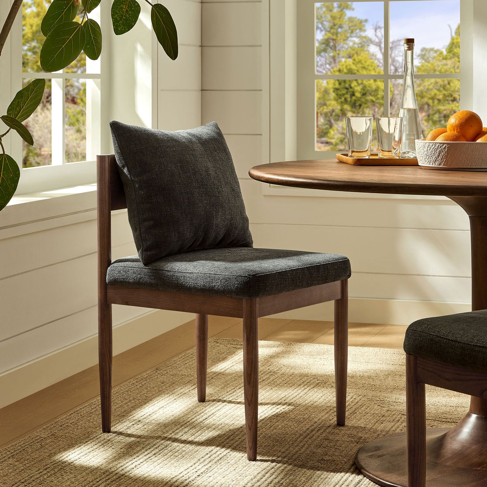 Remington charcoal dining chair paired with round wood table for a warm, modern dining nook. || EEI-7242-CHA || front_angle_room
