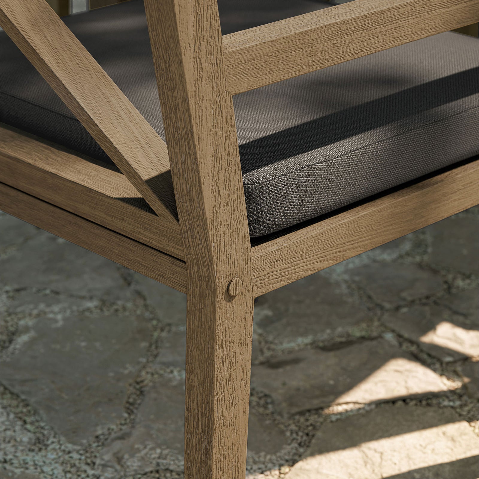 Weathered teak texture, inset bolts, and performance fabric cushion shown in a sunlit patio setting. || EEI-7253-WGR-FLI || leg_room
