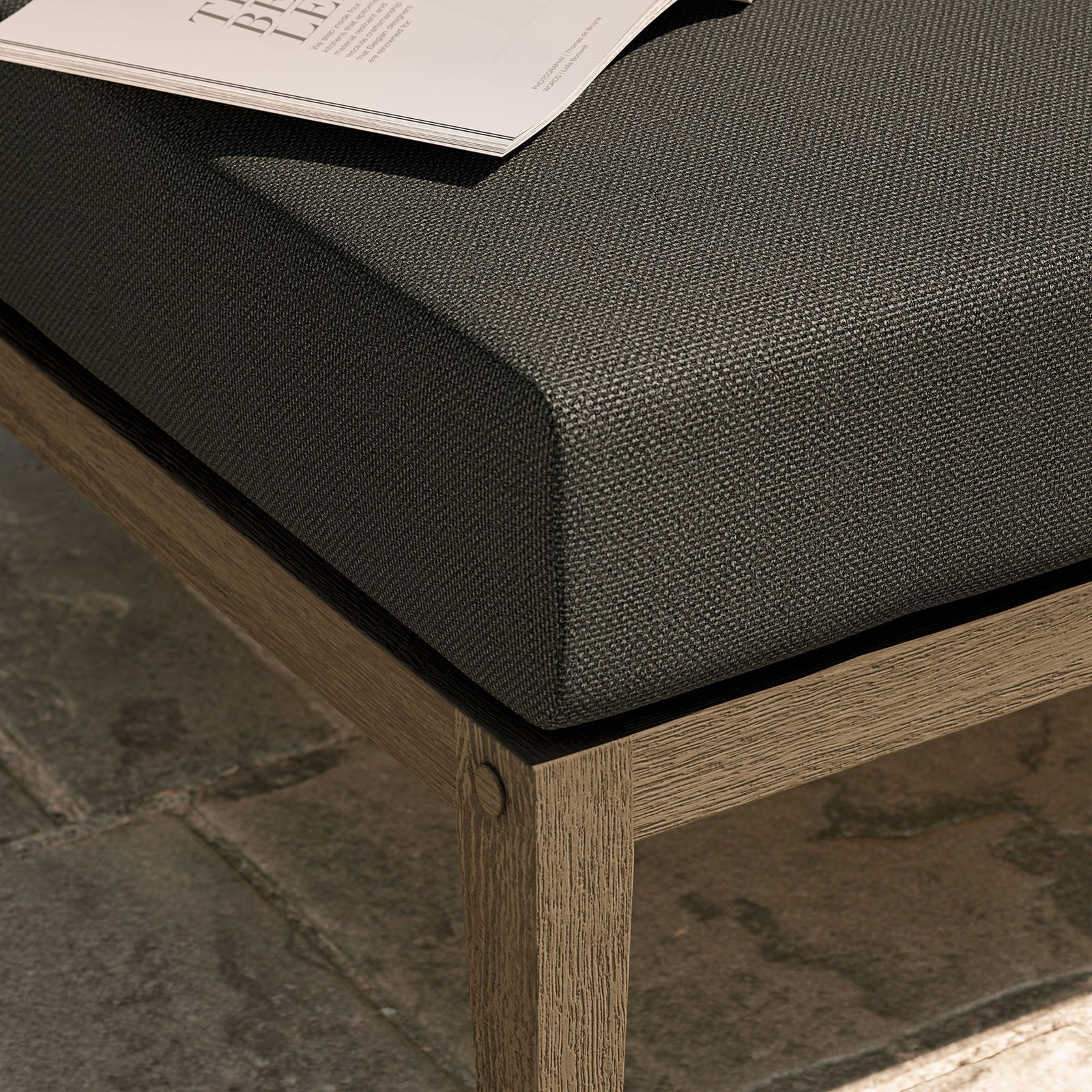 Textured charcoal cushion and teak base bring relaxed comfort to an outdoor stone patio setting || EEI-7255-WGR-FLI || detail_room