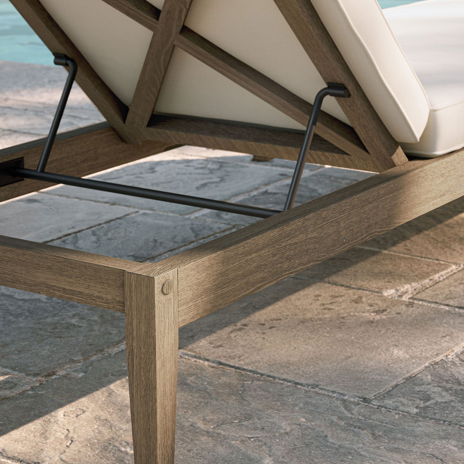 Weathered teak frame and white cushion detail shown beside a sunlit stone poolside patio || EEI-7256-WGR-WHI || detail_room