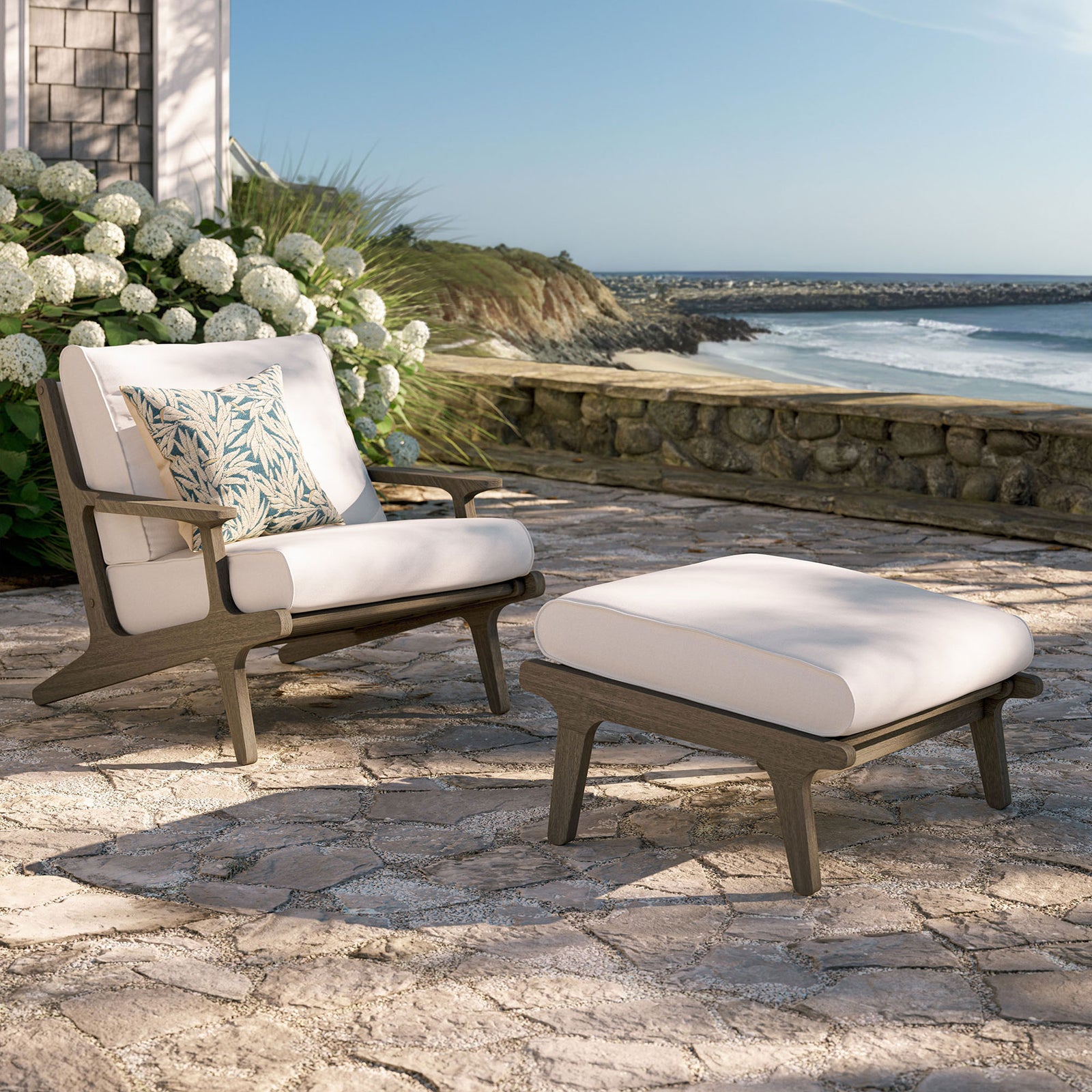 Saratoga white lounge chair and ottoman creating a bright teak retreat on a coastal stone patio || EEI-7268-WGR-WHI || front_angle_room
