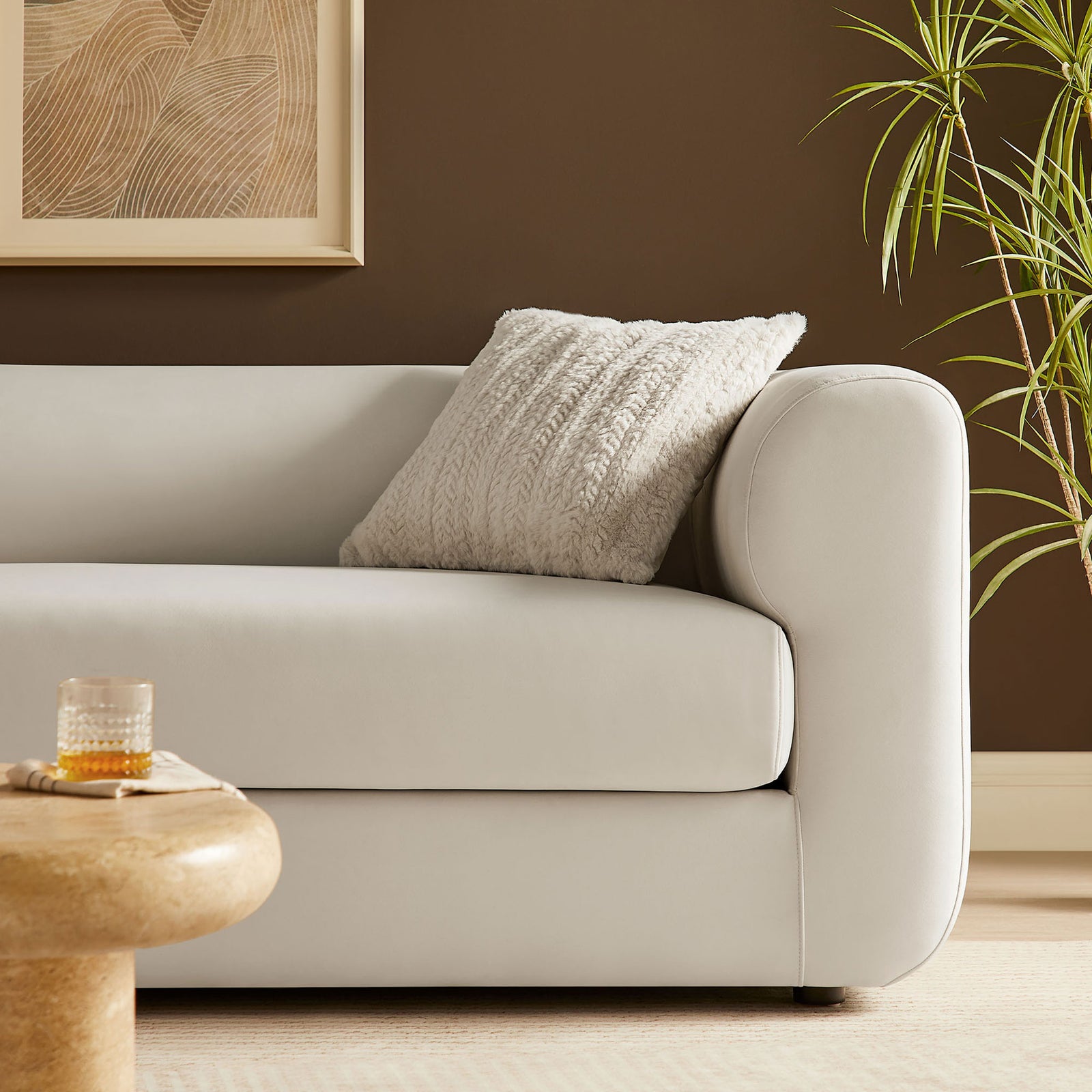 Alabaster velvet sofa styled with a textured throw pillow, creating a cozy contrast against warm modern decor || EEI-7281-ALA || detail_room