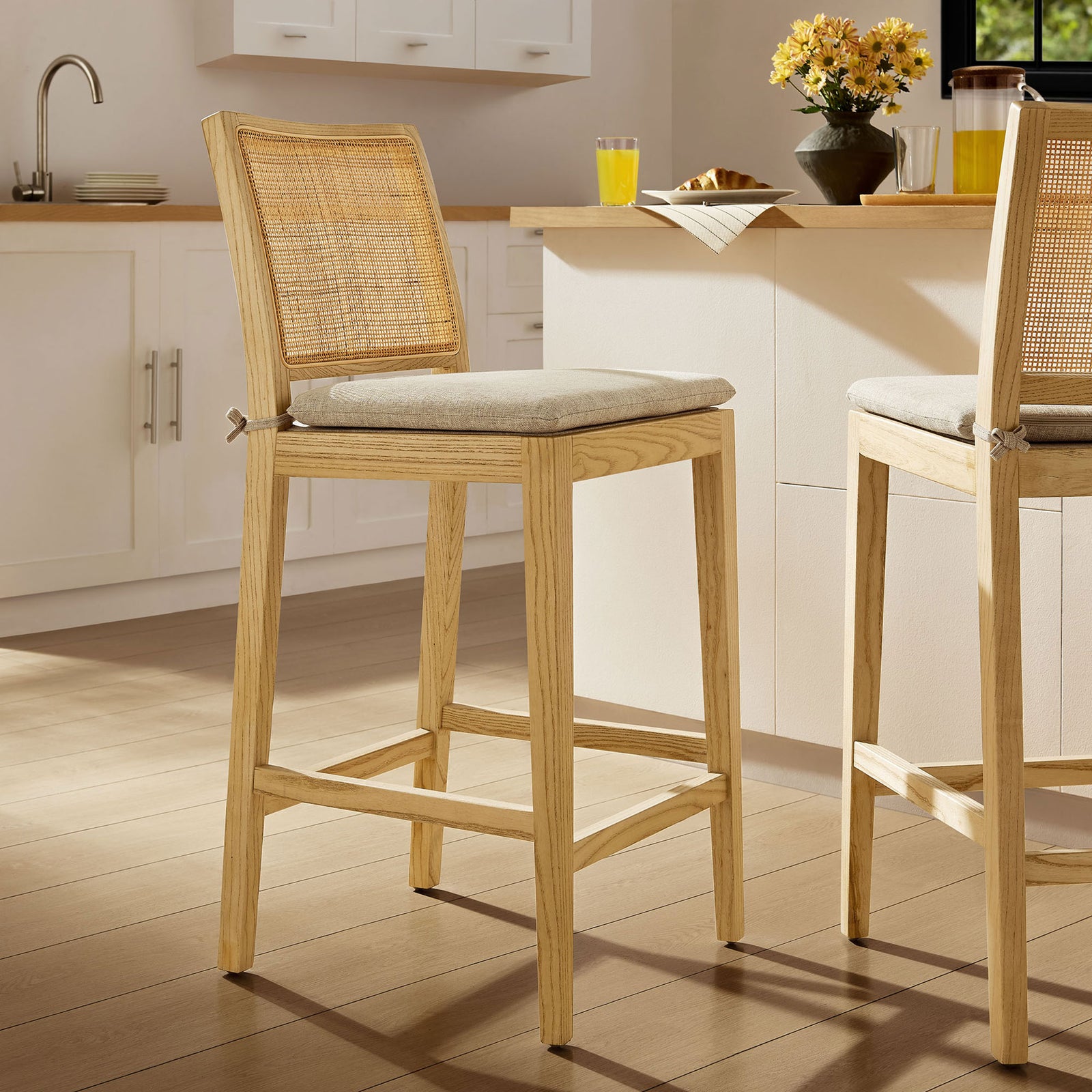 Counter stool brings airy coastal texture to the kitchen with natural wood and cane details. || EEI-7290-NAT-BEI || front_angle_room