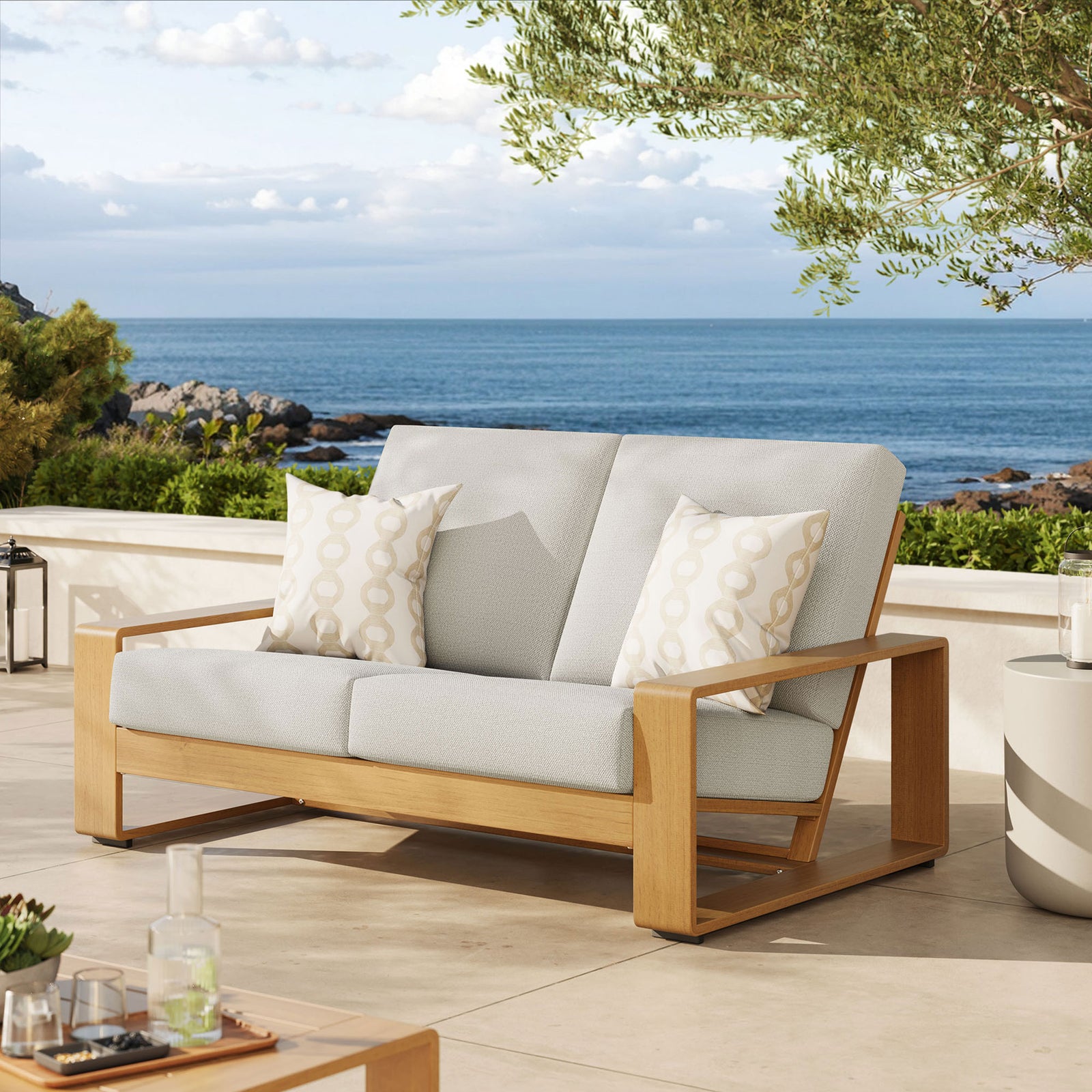 Ivory and natural wood-look loveseat lends airy, relaxed comfort to a sun-washed patio scene || EEI-7297-IVO-NAT || front_angle_room