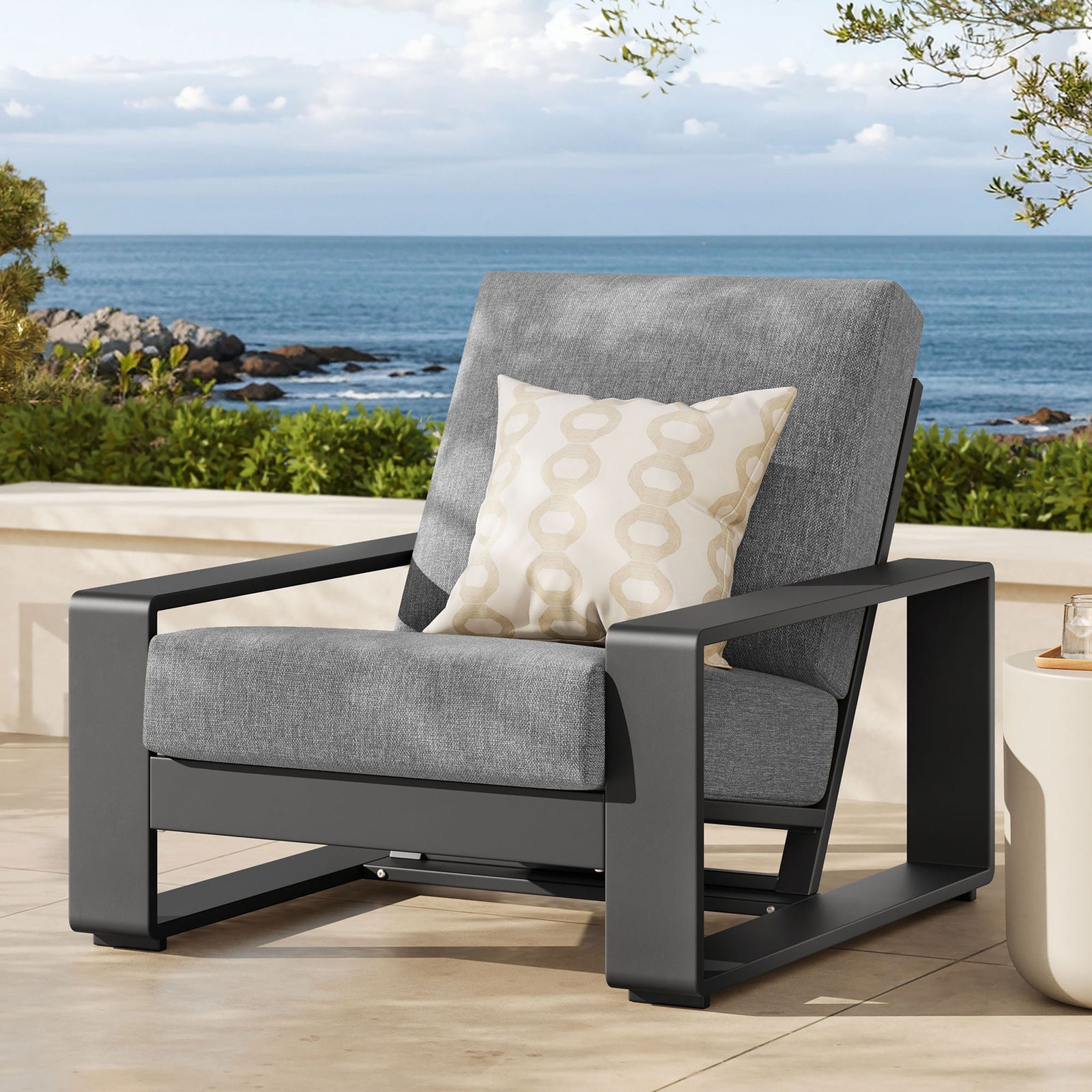 Light gray and charcoal outdoor armchair adding a modern focal point to a breezy coastal patio || EEI-7300-LGR-GRY || front_angle_room