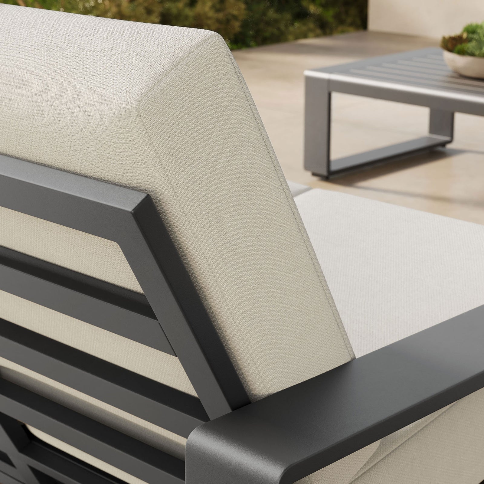 Cushion and arm detail reveals the cream fabric texture against the sleek charcoal aluminum frame || EEI-7301-CRE-GRY || detail_room