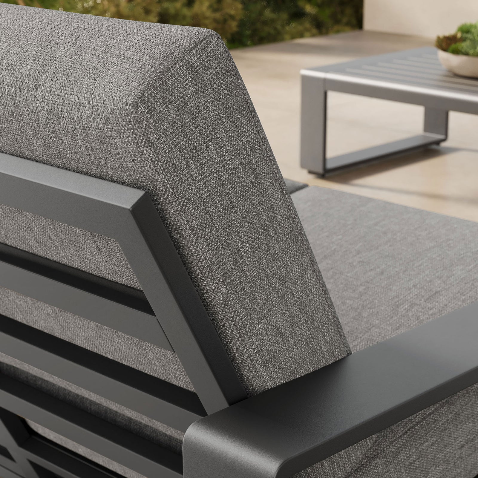 Softly textured light gray upholstery meets the dark frame, highlighted against a lush outdoor backdrop || EEI-7301-LGR-GRY || detail_room