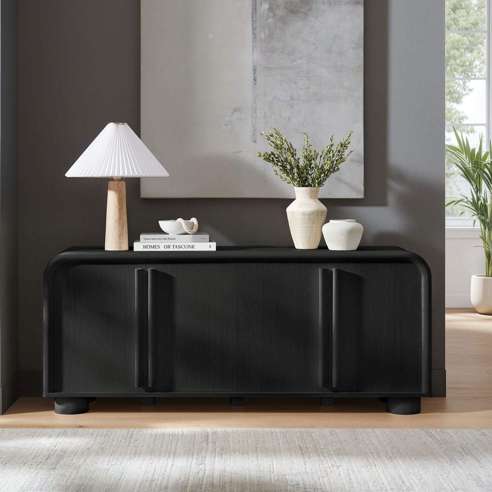 Bellamy black oak sideboard styled in a modern living room with decor accents and soft natural light || EEI-7315-BLK || front_angle_room
