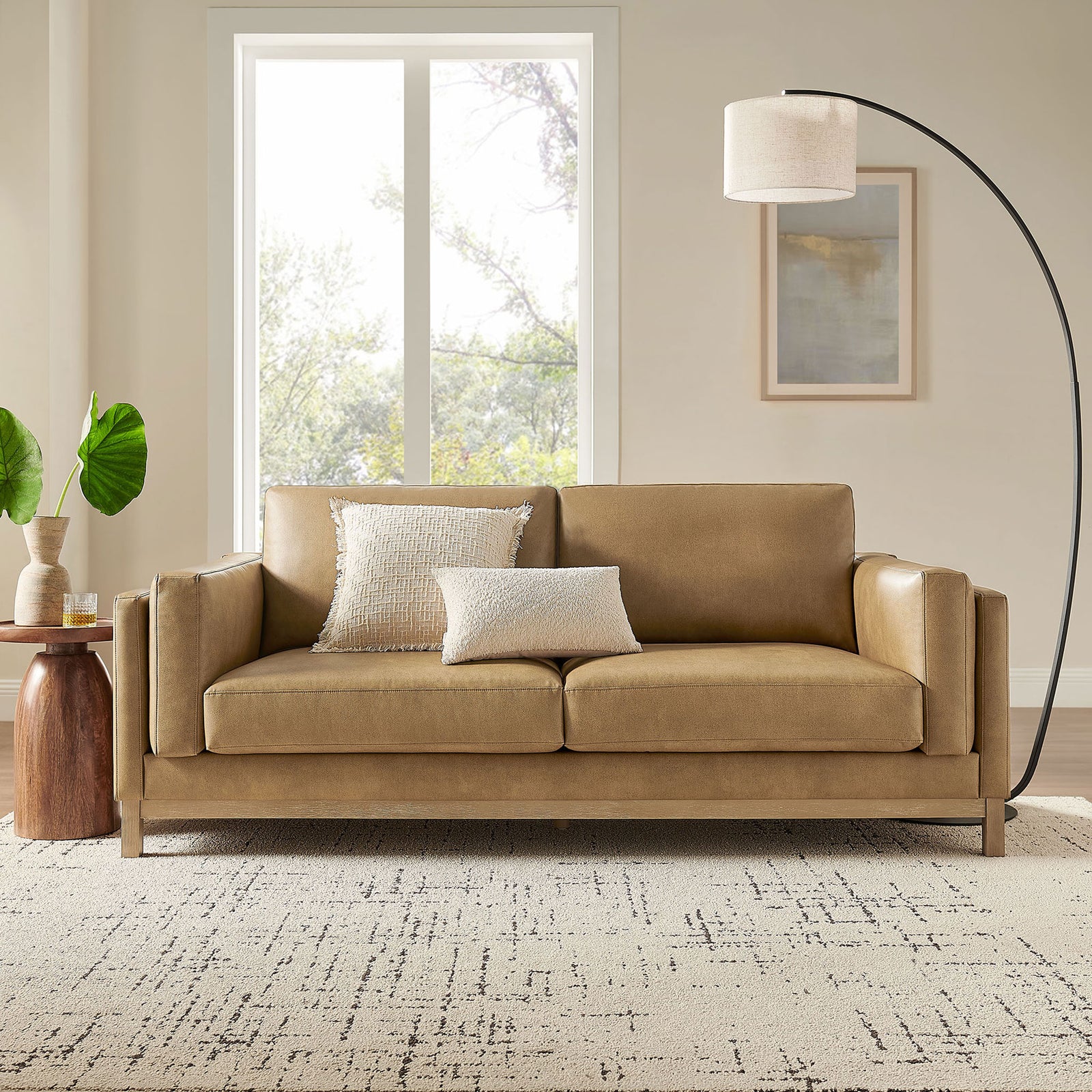 Roscoe toast vegan leather sofa styled in a cozy living room with layered pillows, rug, and floor lamp || EEI-7335-TST || front_room