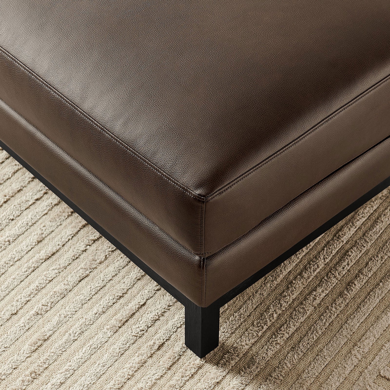 Textured espresso vegan leather Roscoe ottoman corner on patterned rug in living room. || EEI-7338-ESP || detail_room