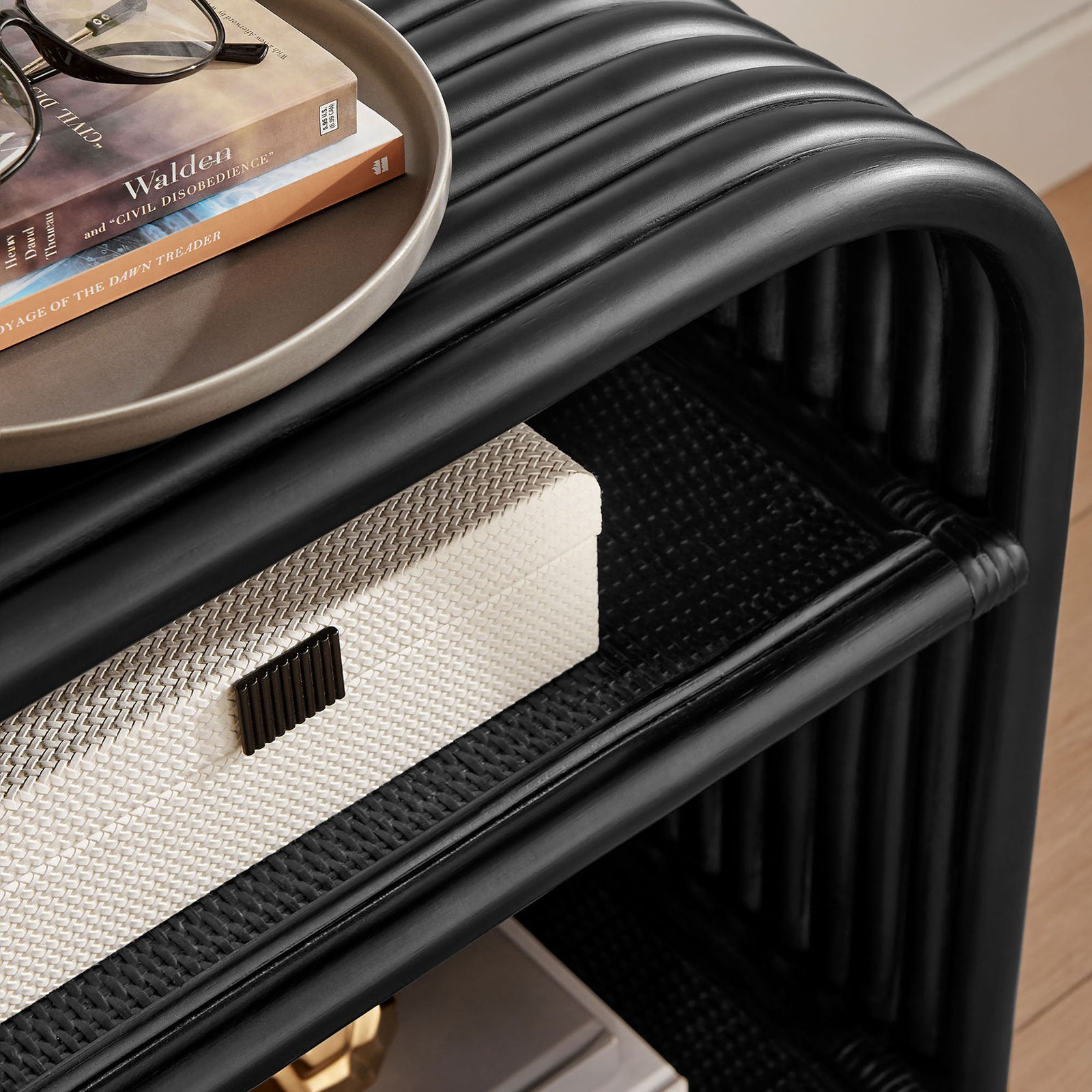 Styled black rattan side table top arranged with books, a tray, and decorative accents || EEI-7361-BLK || detail_room
